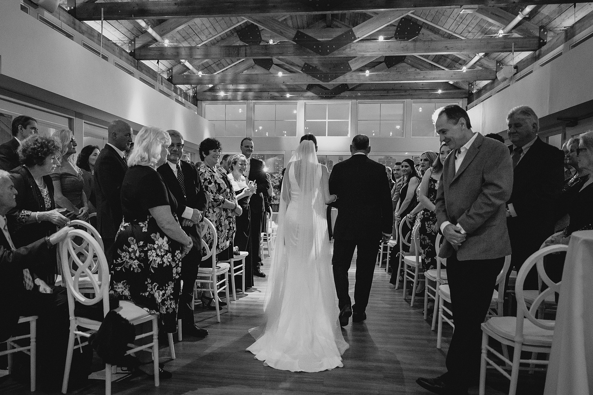 bride walks down aisle with father for ceremony at Maritime Parc