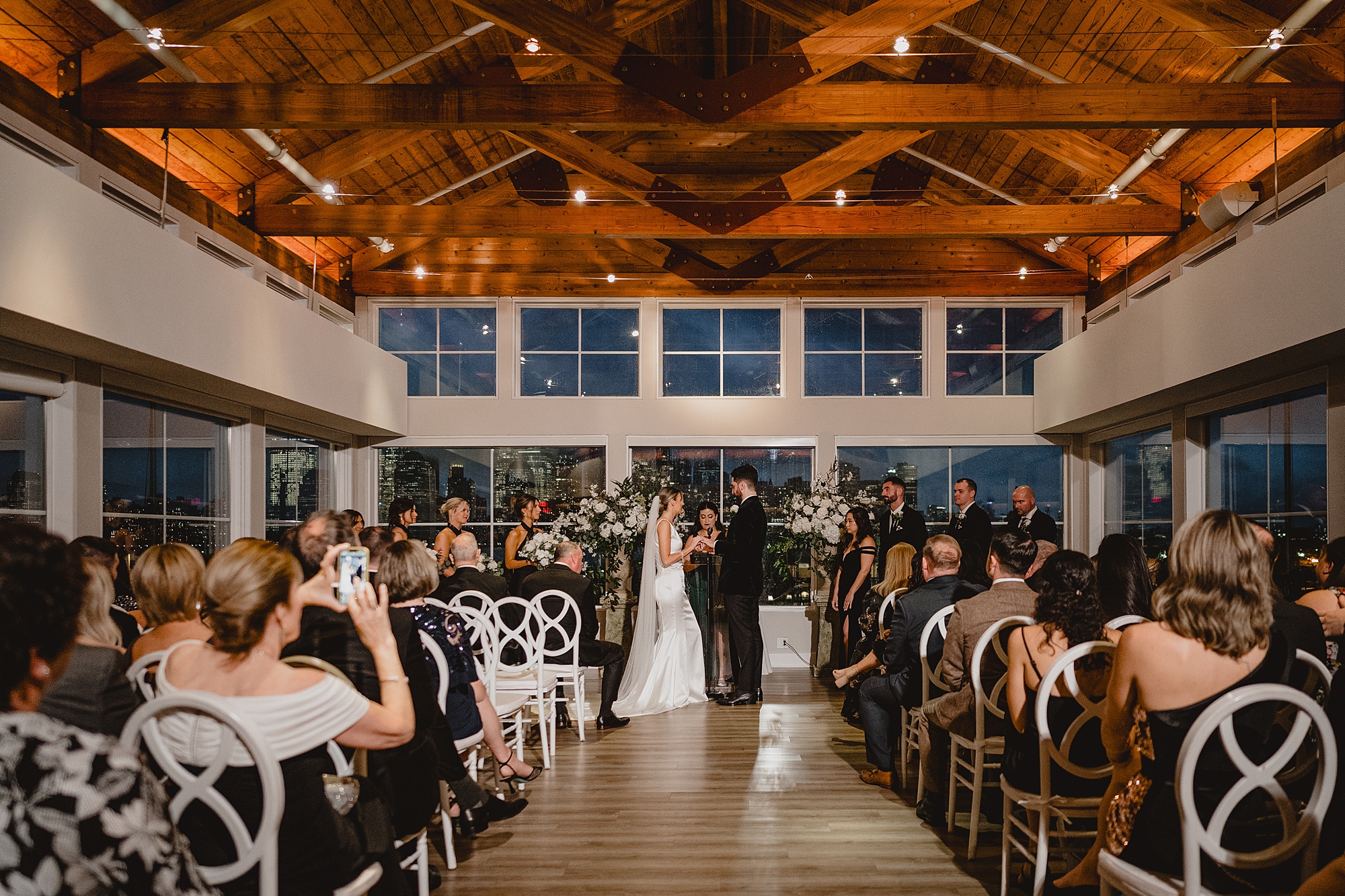 bride and groom hold hands during ceremony inside Maritime Parc
