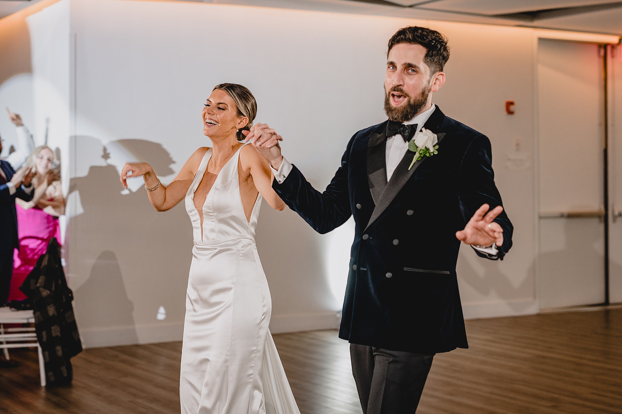 bride and groom hold hands walking into reception