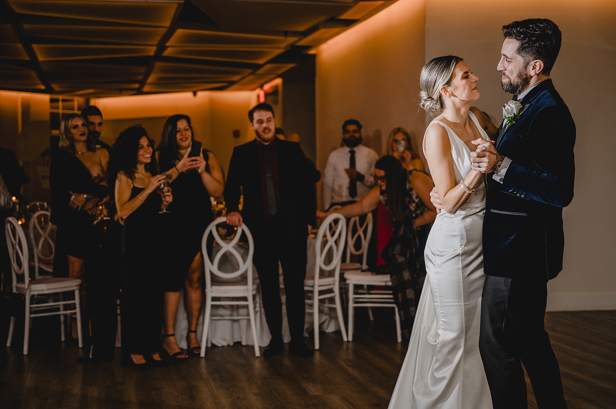 groom hugs bride to him during first dance at Maritime Parc
