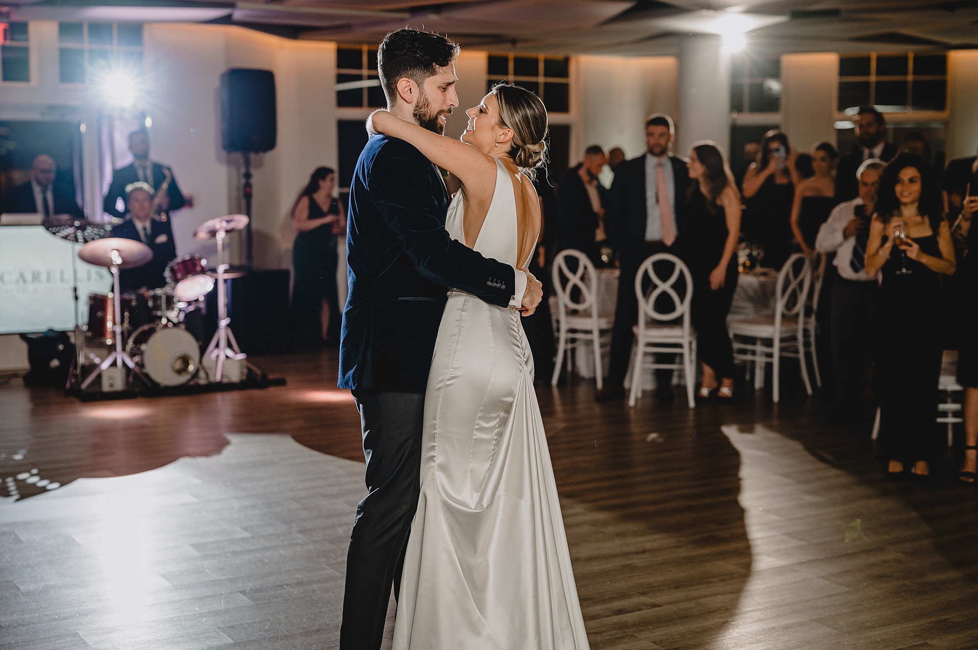 groom hugs bride to him during first dance at Maritime Parc