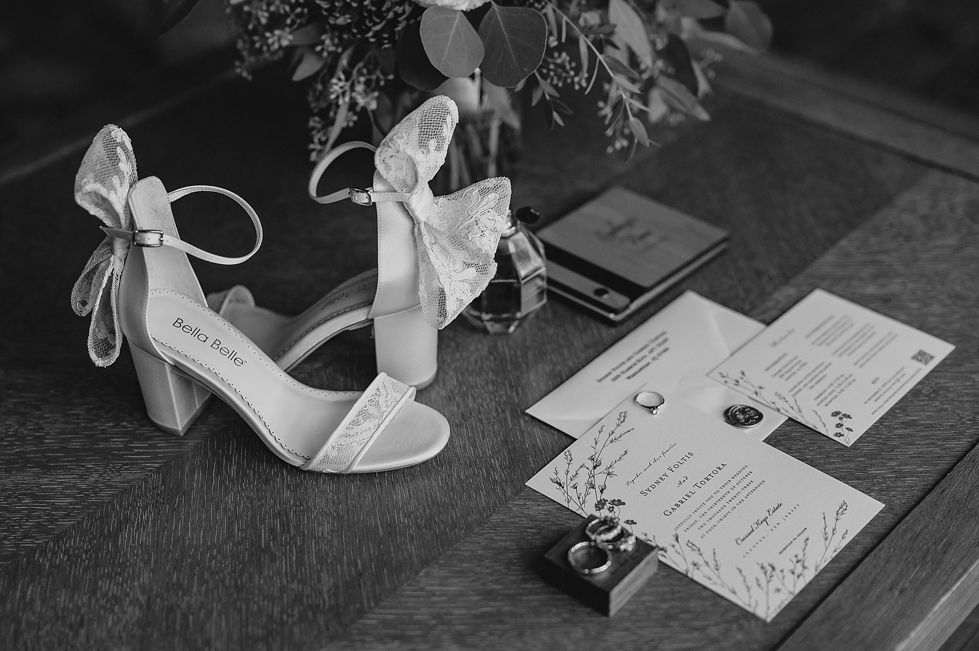 bride's shoes with lace bows next to invitation suite for fall wedding