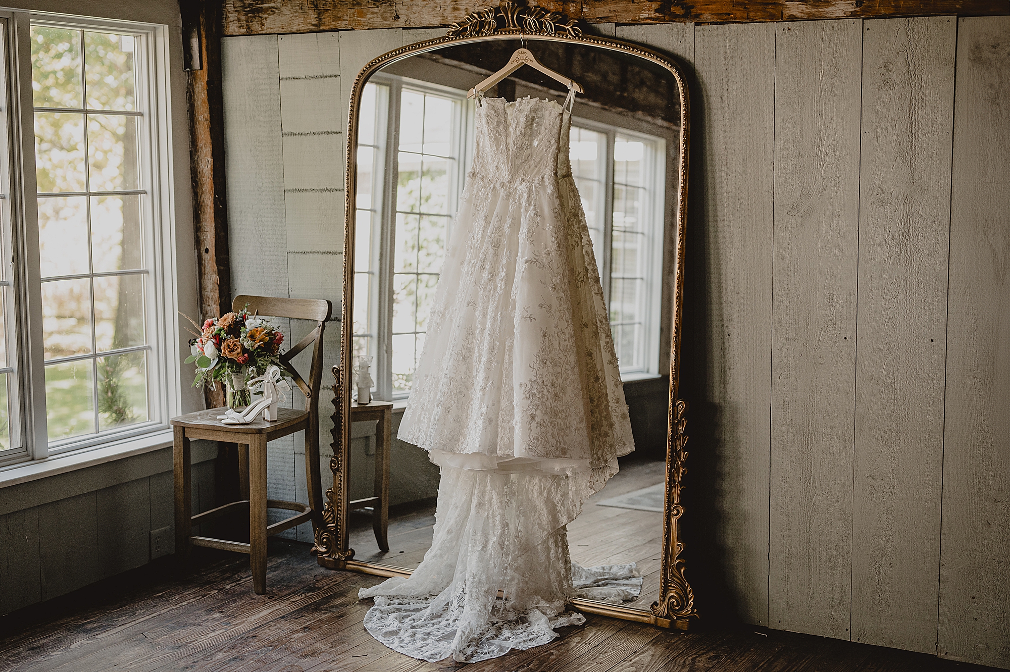 wedding dress hangs on gold framed mirror at Crossed Keys Estate