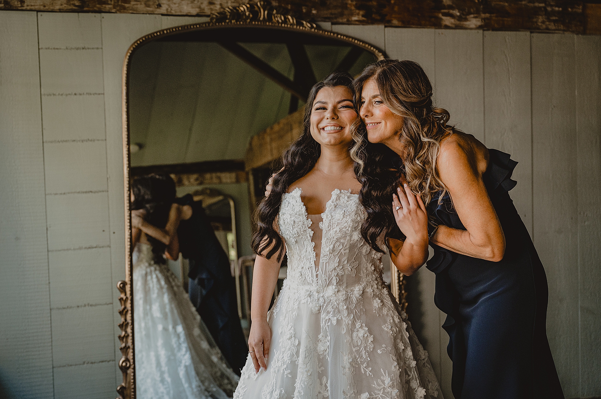 mother hugs bride smiling in front of mirror at Crossed Keys Estate