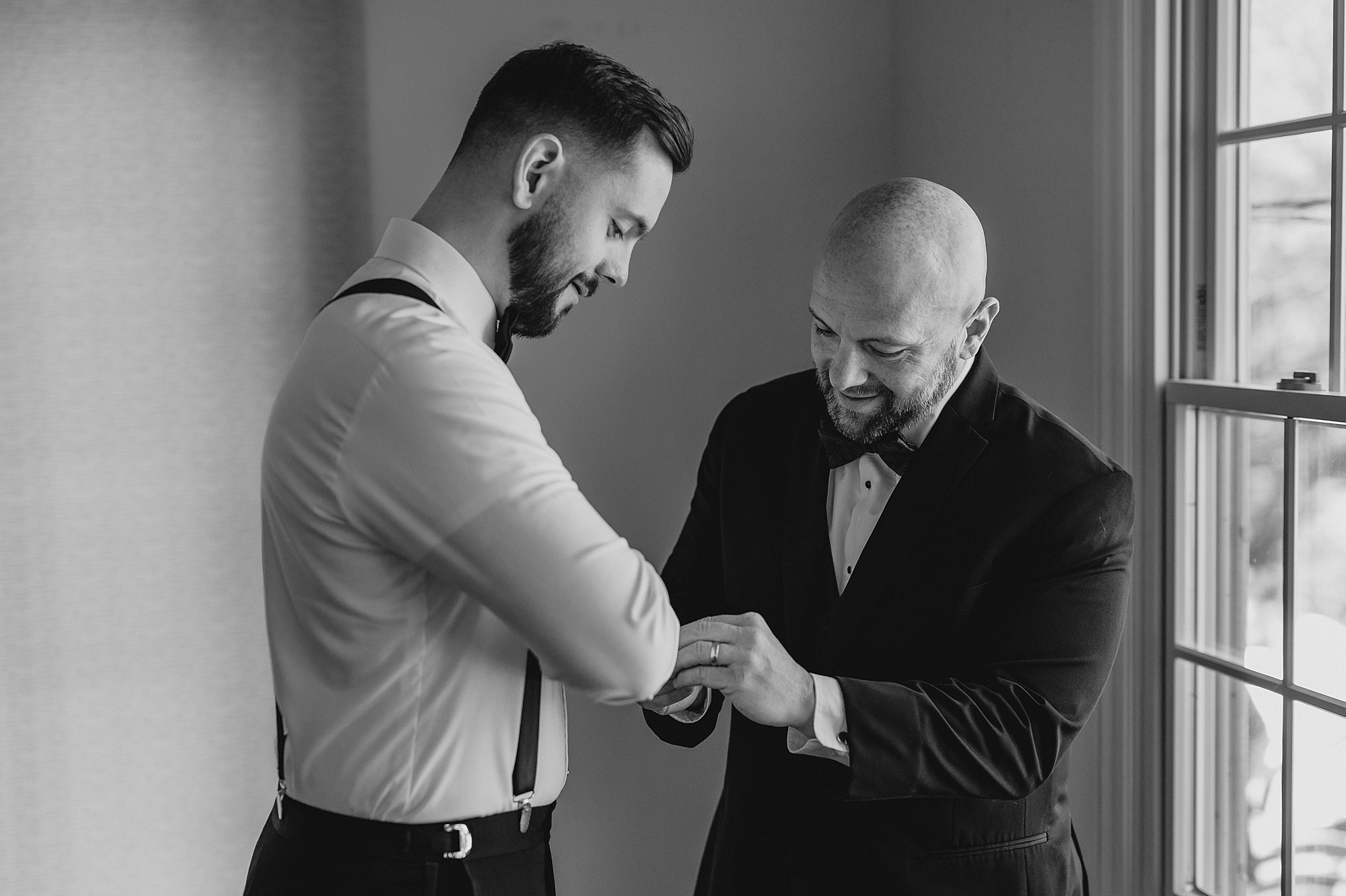 groomsman helps groom with custom cufflinks