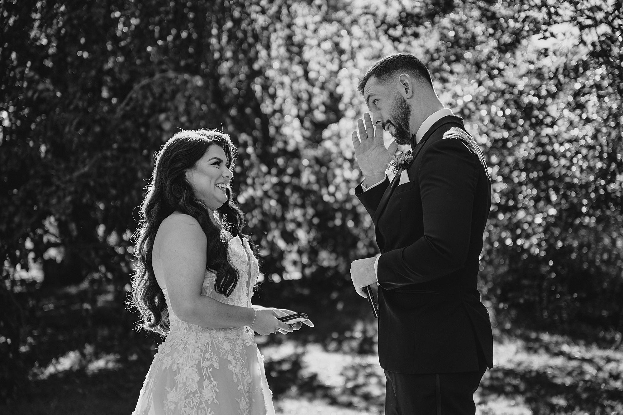 groom wipes away tears during first look with bride