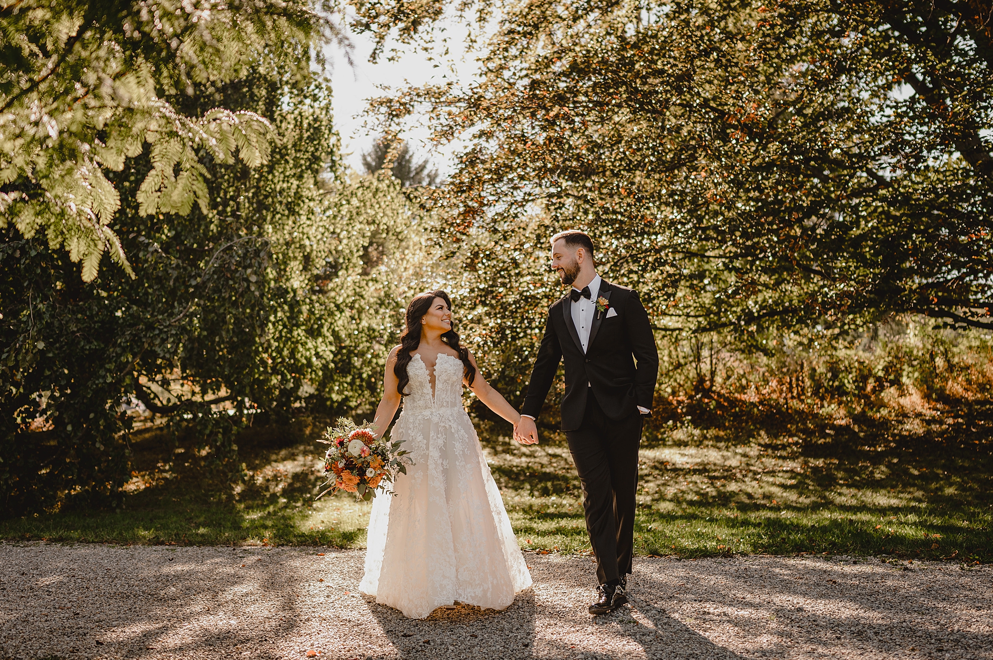 bride and groom walk through garden at Crossed Keys Estate