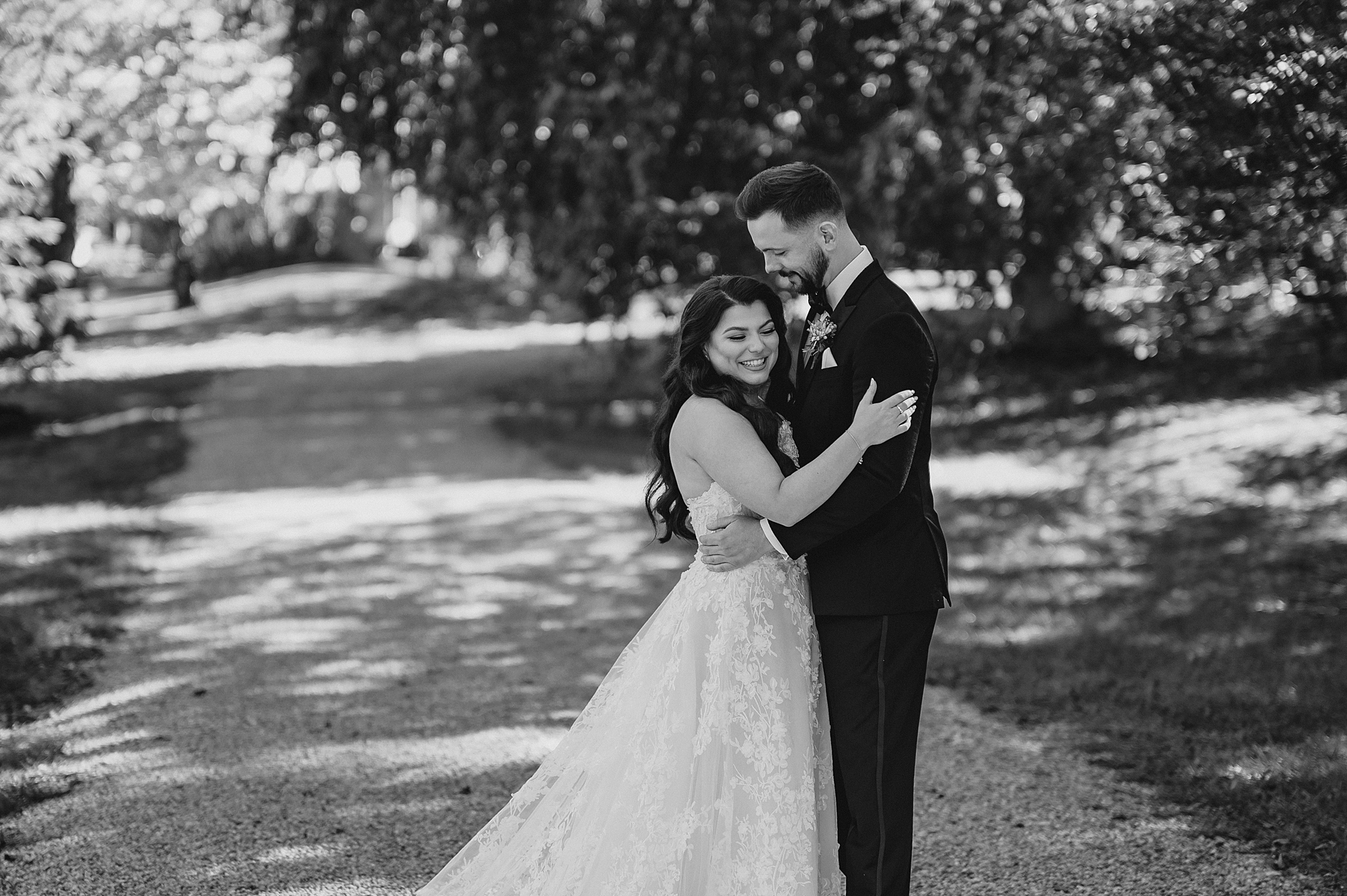 bride leans into groom hugging him in garden at Crossed Keys Estate