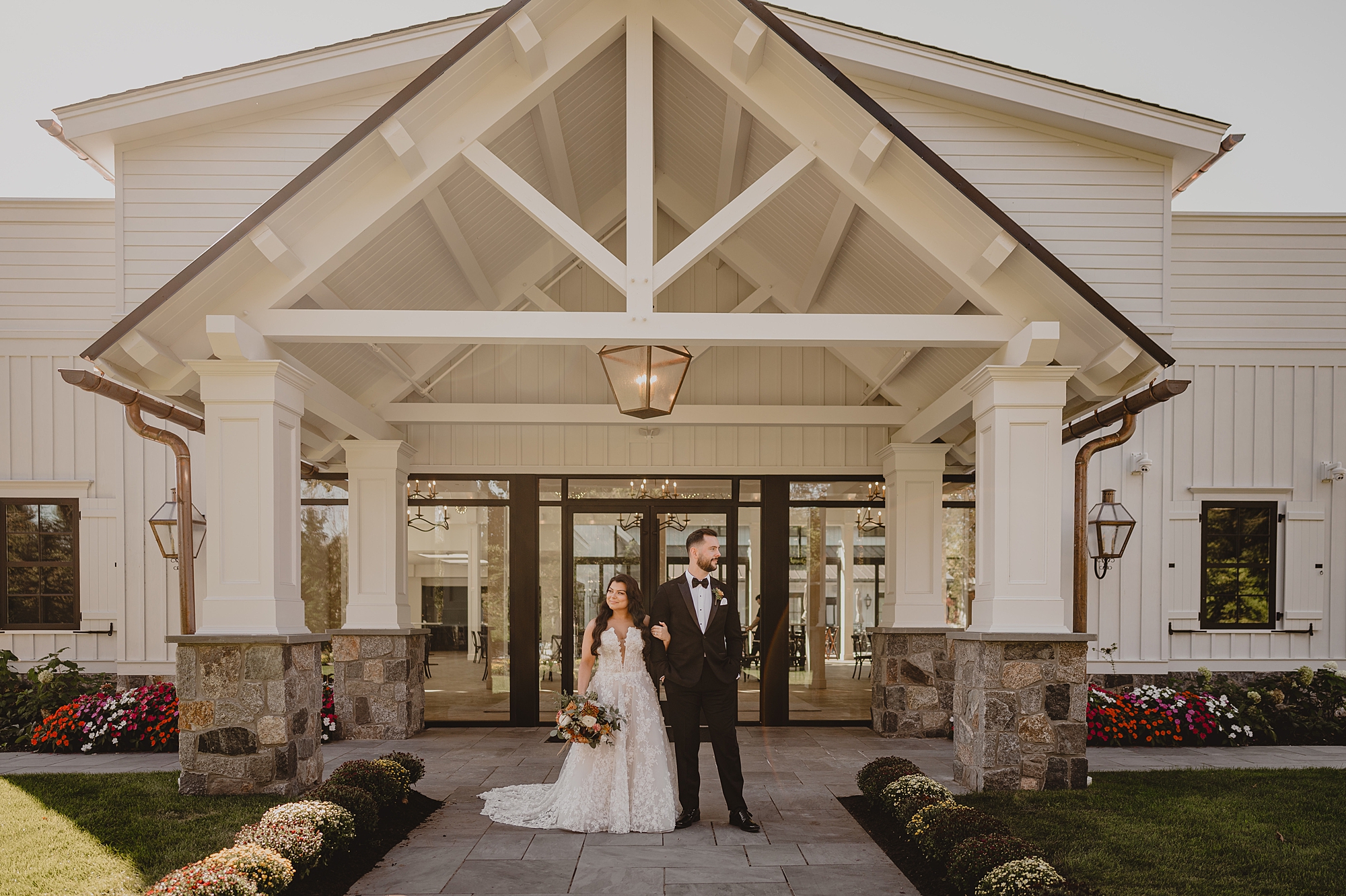 newlyweds hold hands under awning of Crossed Keys Estate