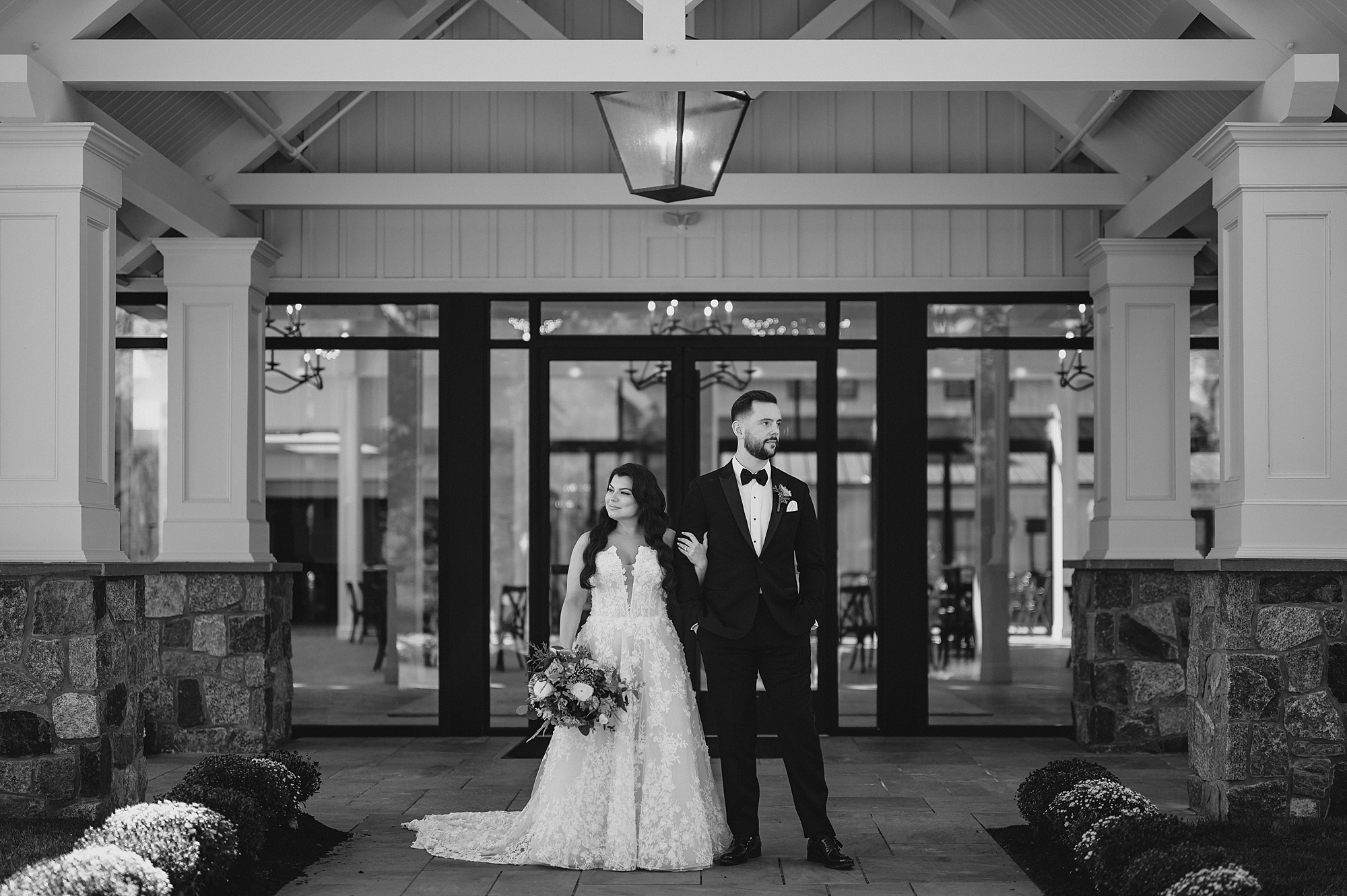 bride and groom stand in front of front door of Crossed Keys Estate