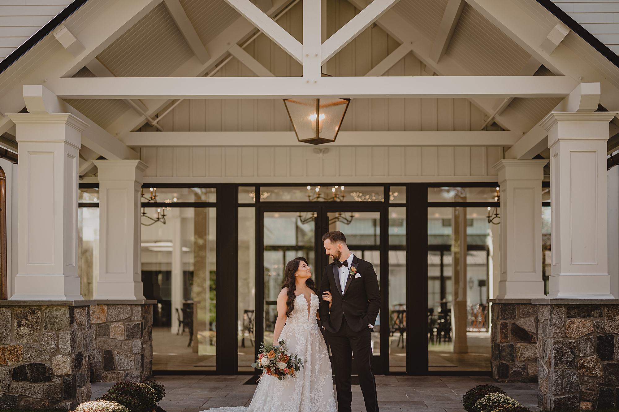 newlyweds smile hugging outside Crossed Keys Estate