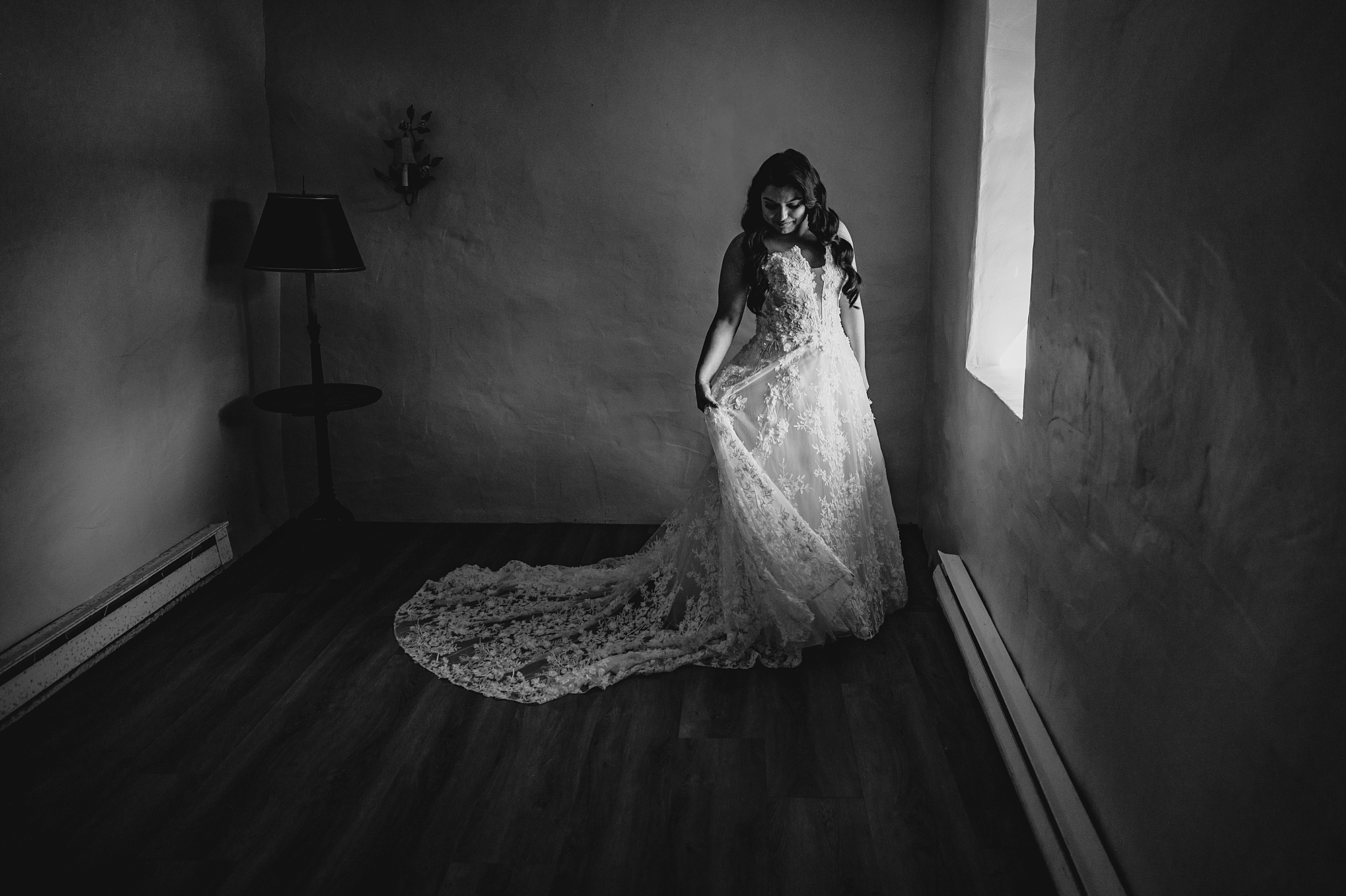 bride looks back over shoulder near window at Crossed Keys Estate