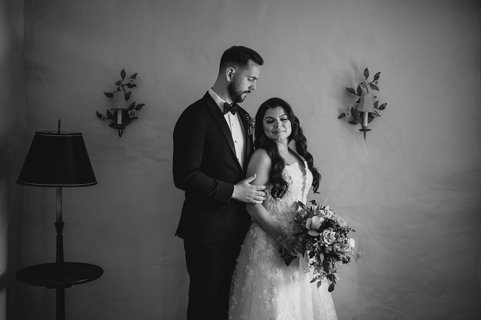 groom stands behind bride inside Crossed Keys Estate