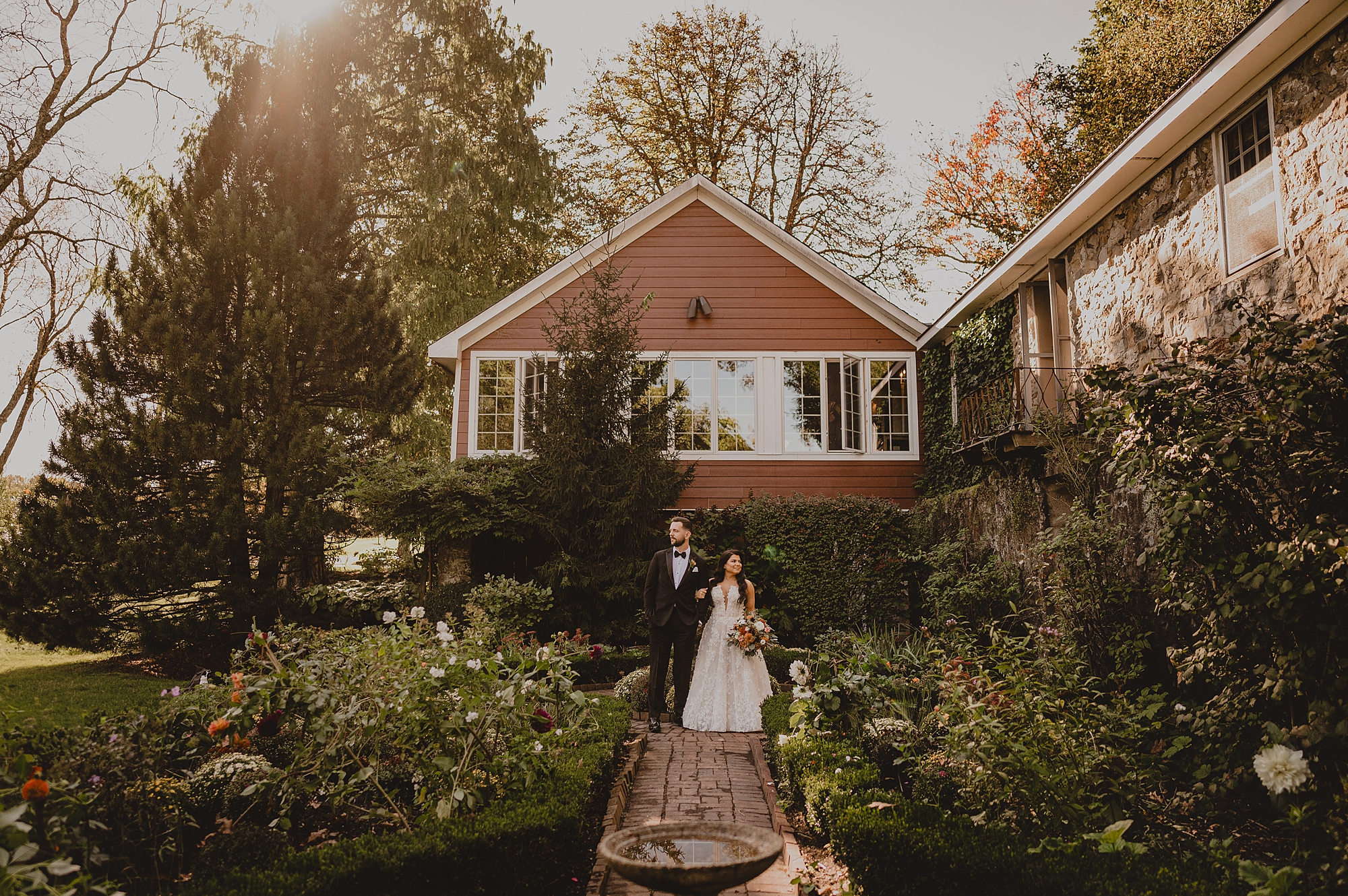bride and groom walk on brick pathway in garden at Crossed Keys Estate