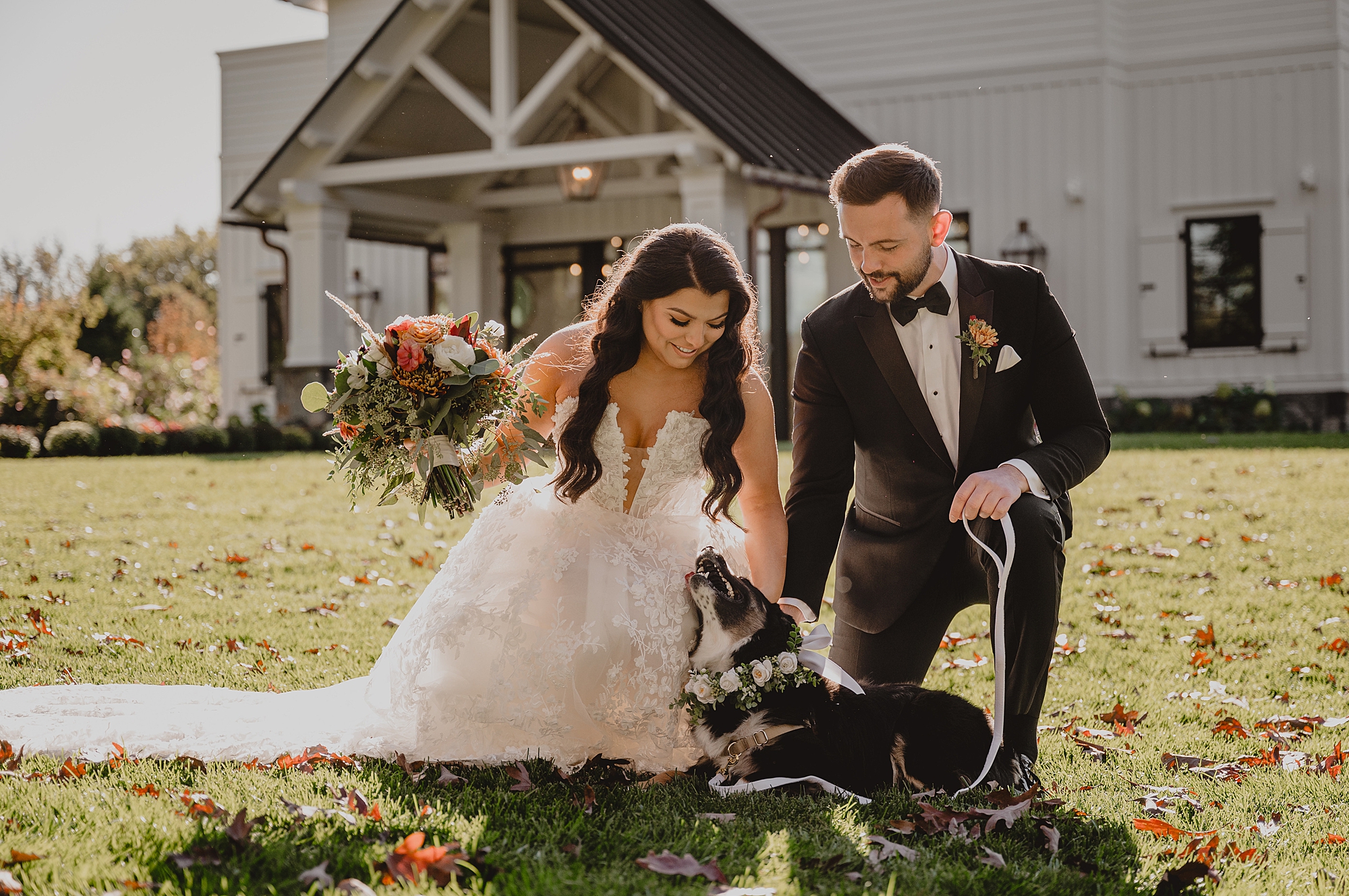 newlyweds kneel down to pet dog outside Crossed Keys Estate