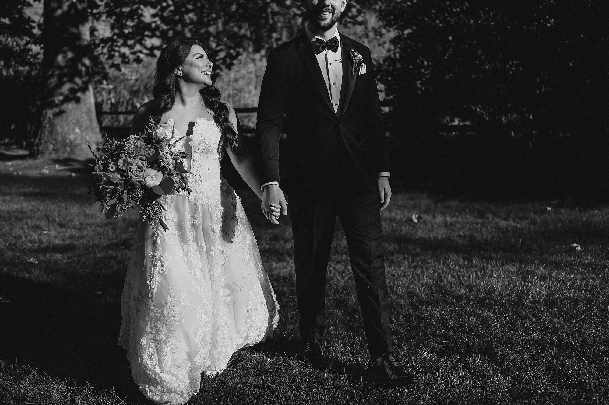 bride and groom hold hands walking on lawn at Crossed Keys Estate