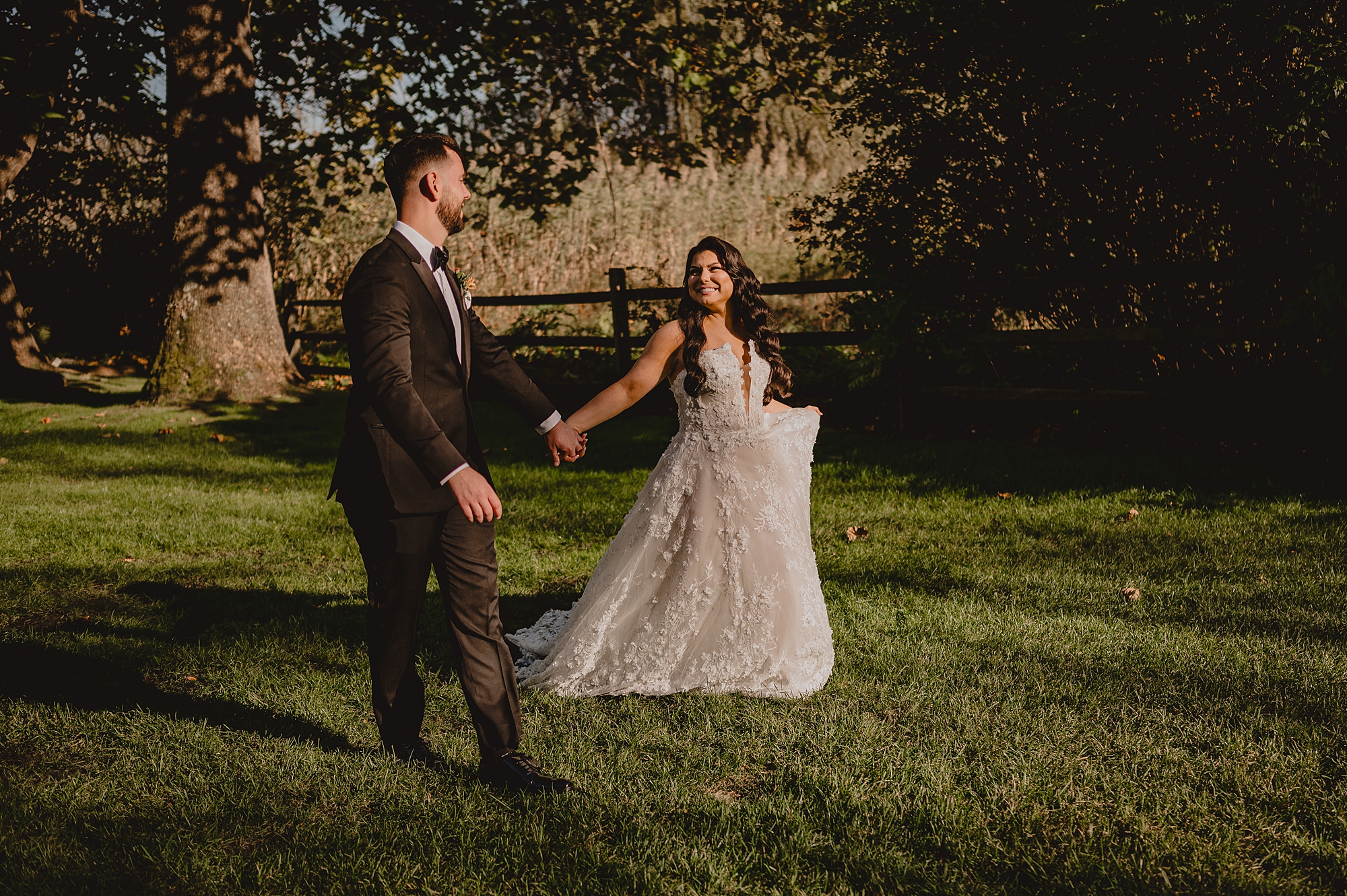 groom holds bride's hand holding her out to twirl