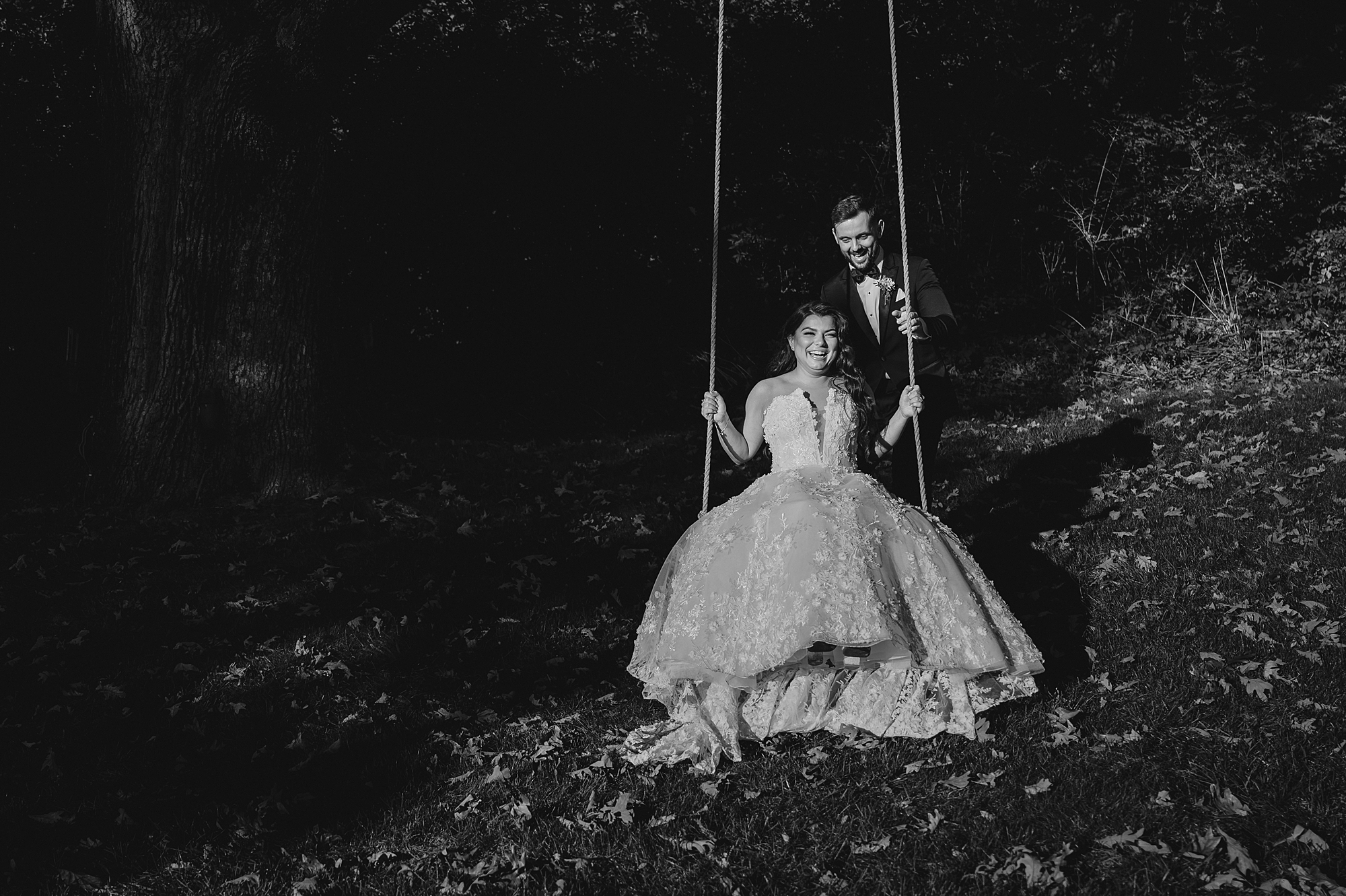 groom pushes bride on wooden swing at Crossed Keys Estate