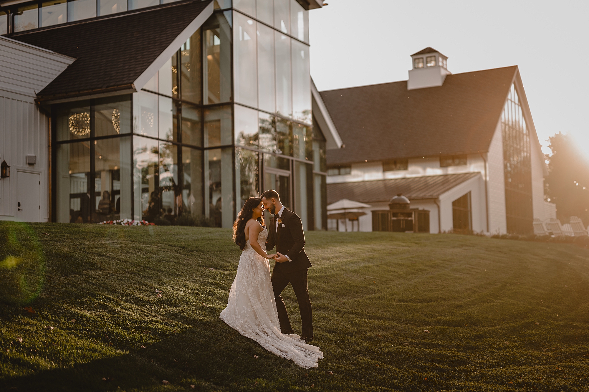 newlyweds pose in front of glass windows at Crossed Keys Estate