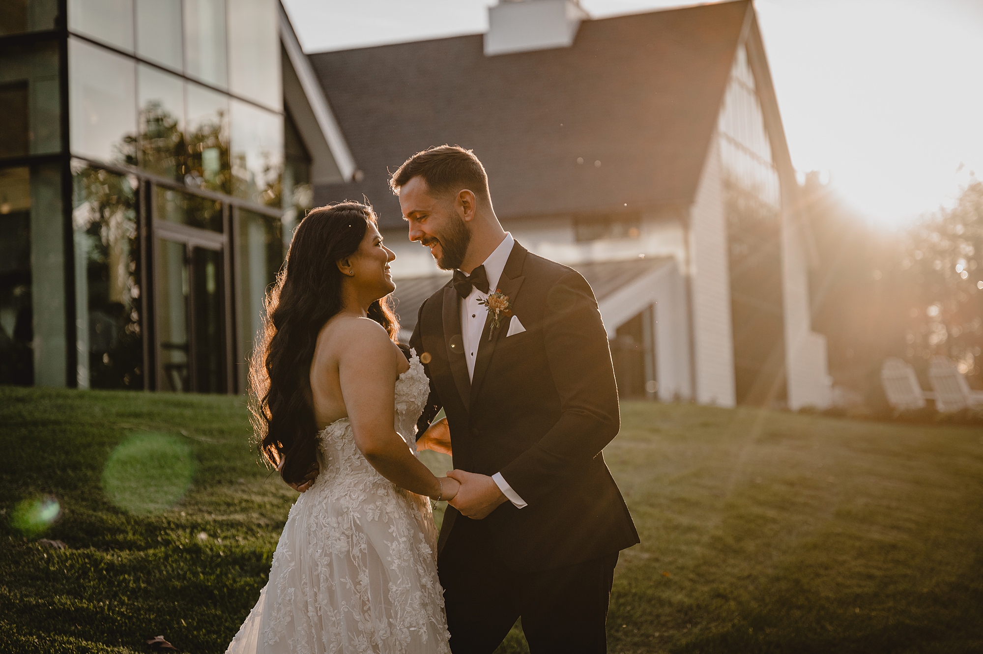 bride and groom hug at sunset in front of Crossed Keys Estate
