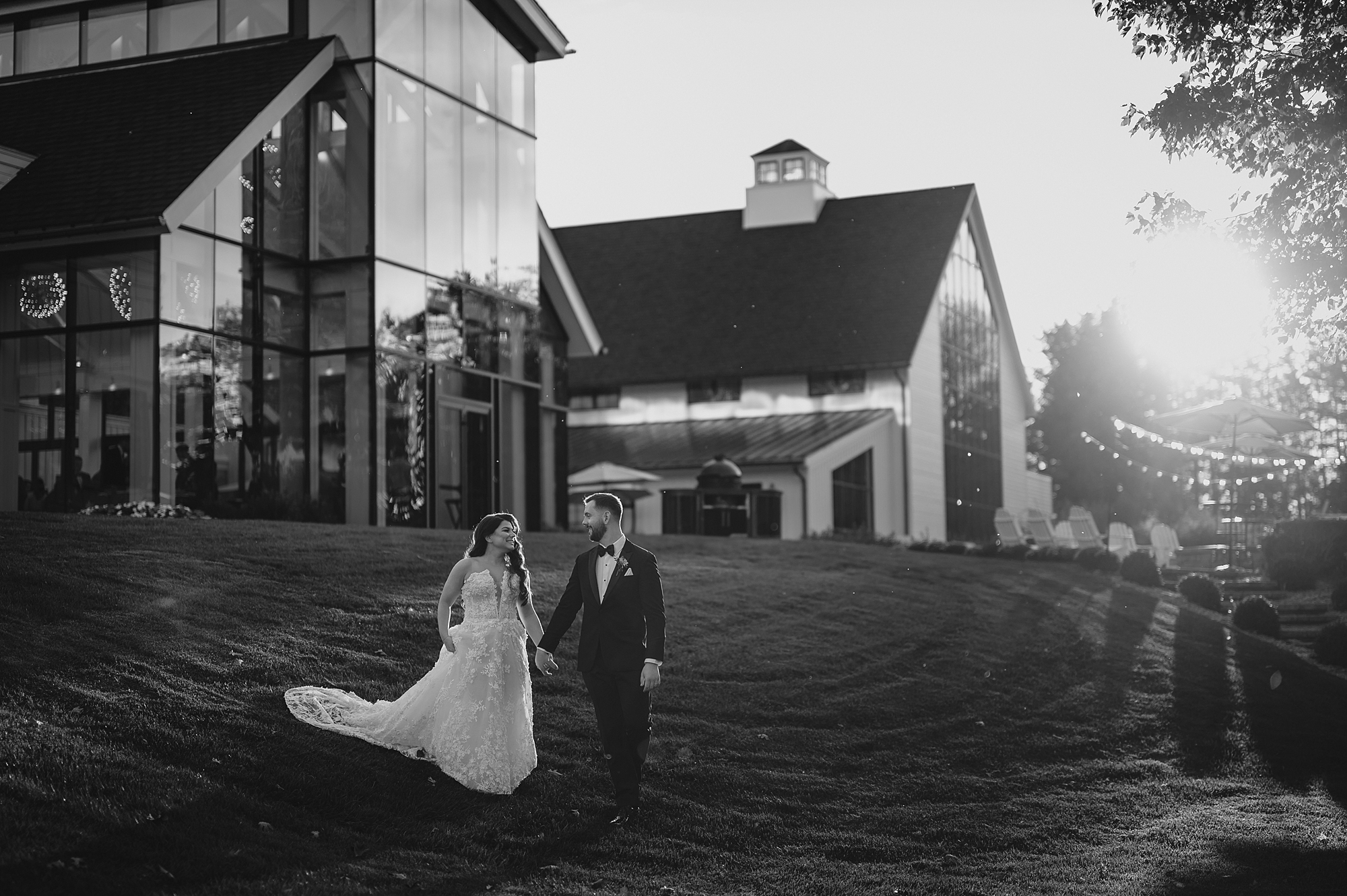 newlyweds walk down hill away from Crossed Keys Estate