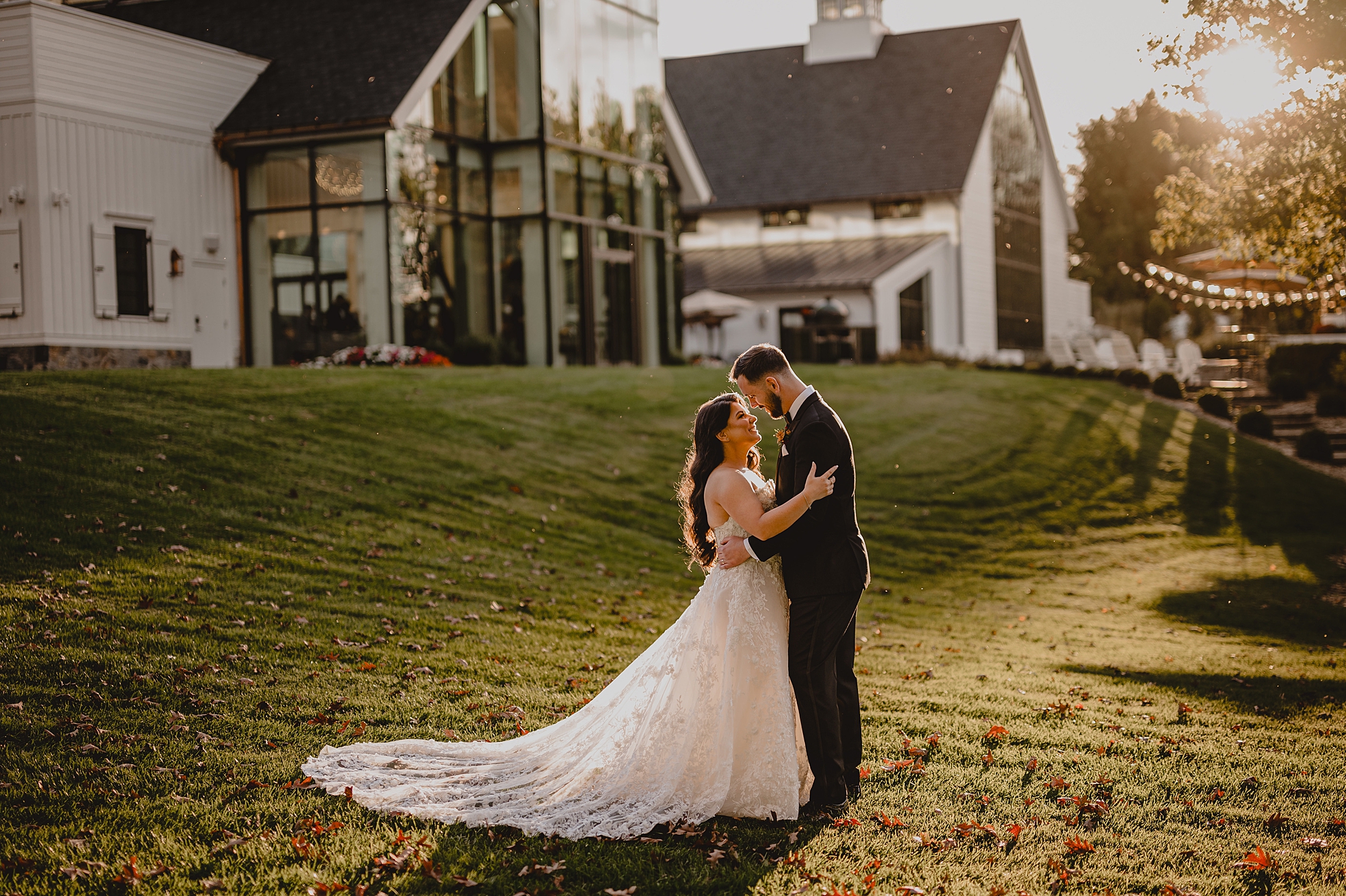 bride and groom hug on lawn for fall wedding photos at Crossed Keys Estate