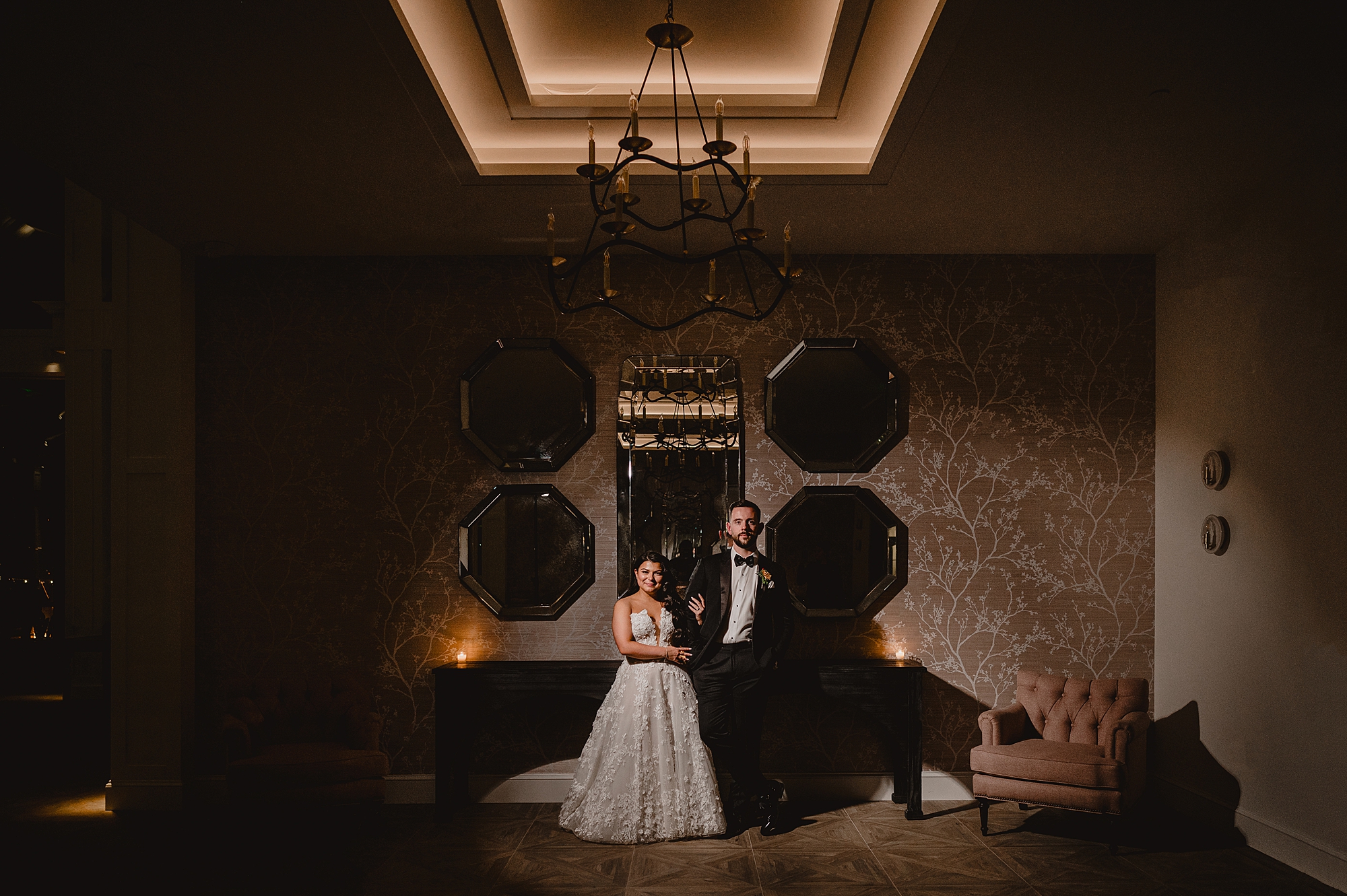 bride and groom pose by fire pit on brick patio at Crossed Keys Estate