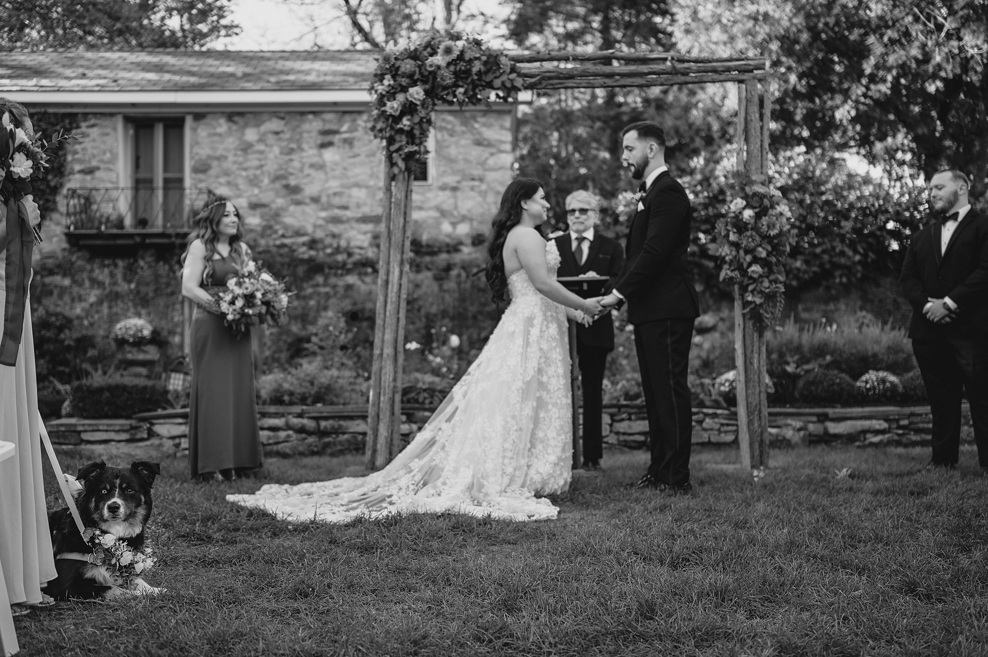 bride and groom hold hands during ceremony on lawn at Crossed Keys Estate