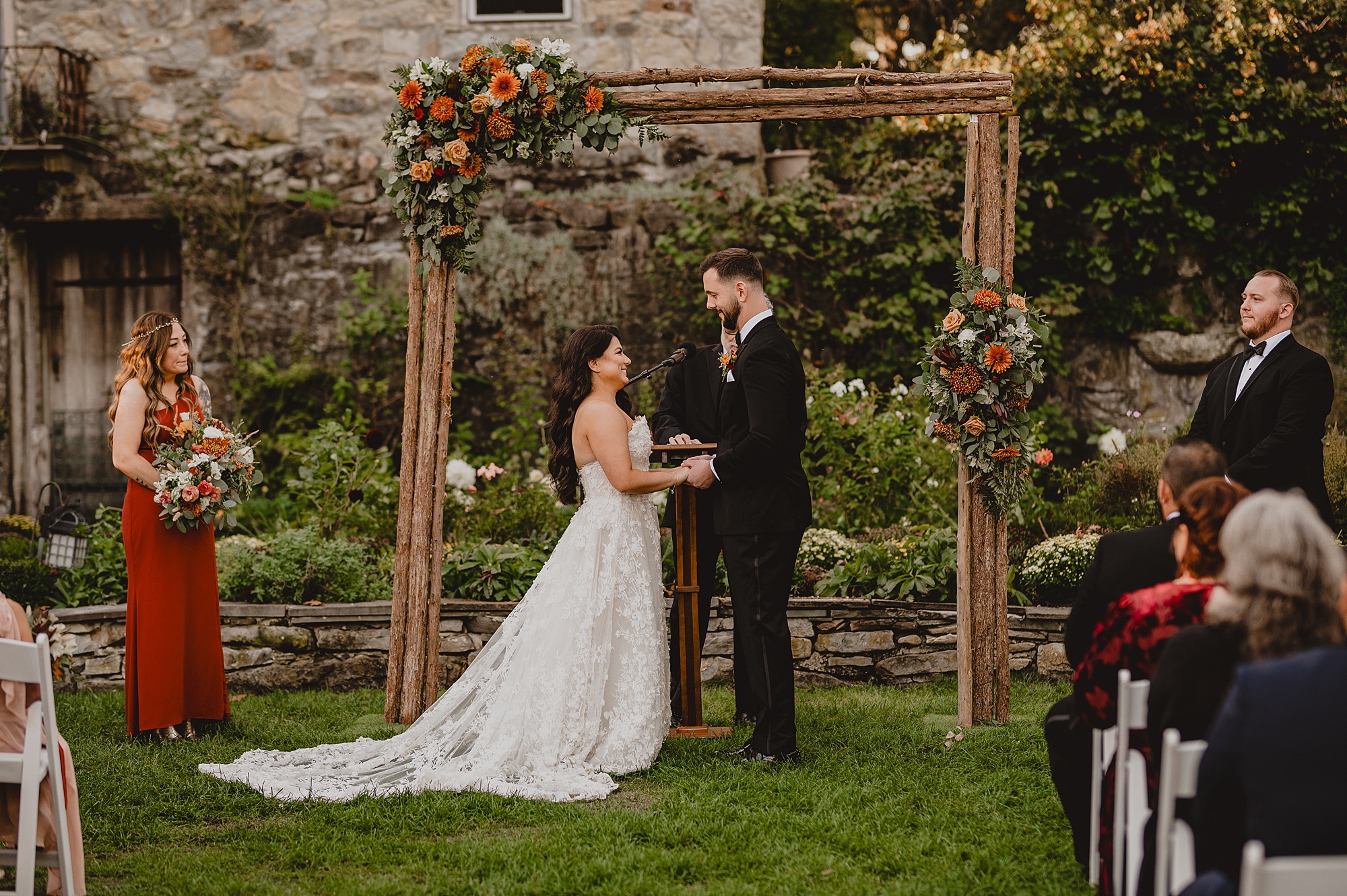 bride and groom hold hands under arbor at Crossed Keys Estate