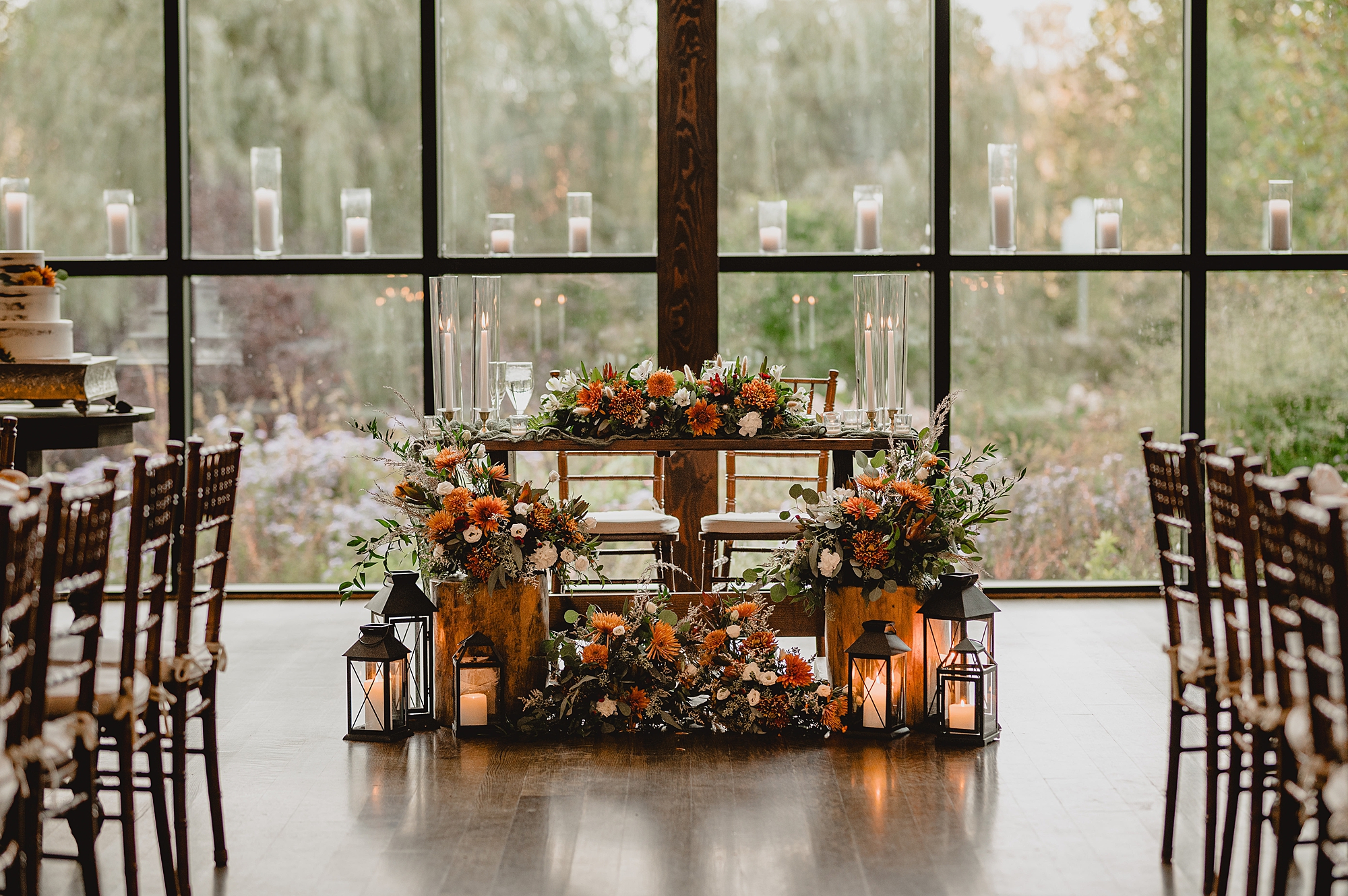 sweetheart table at Crossed Keys Estate with fall florals and candles around the bottom