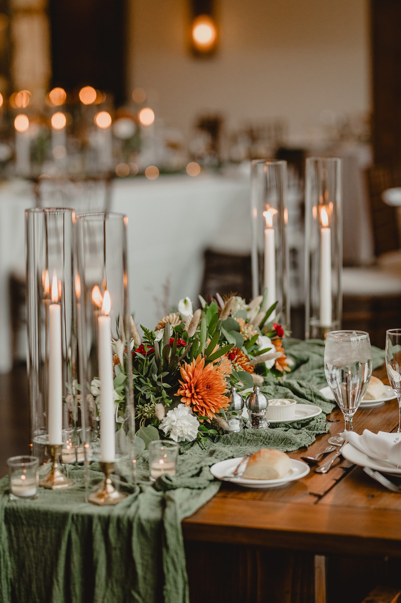 wedding reception on wooden tables with white taper candles