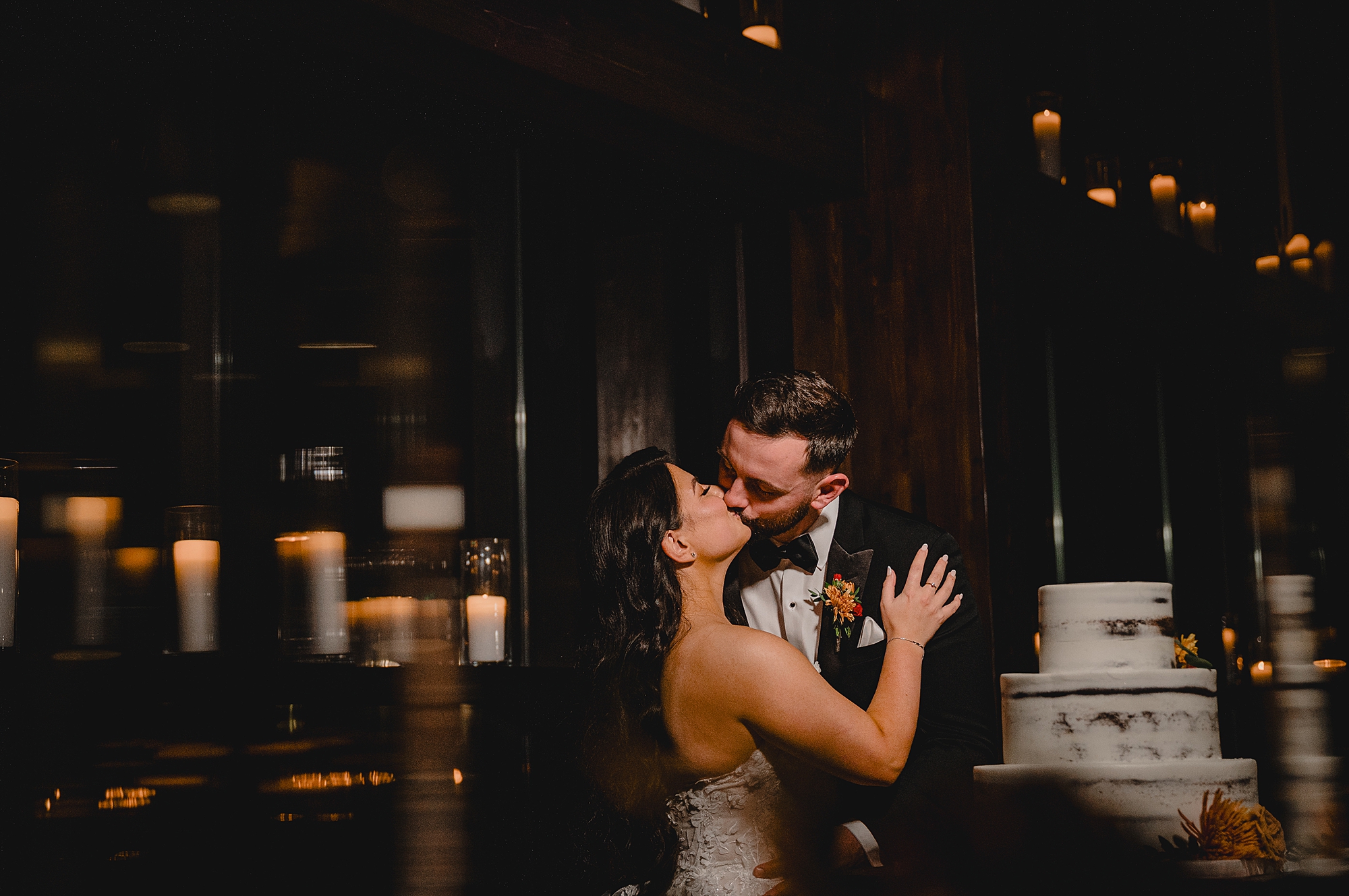 newlyweds kiss by cake at Andover NJ wedding reception