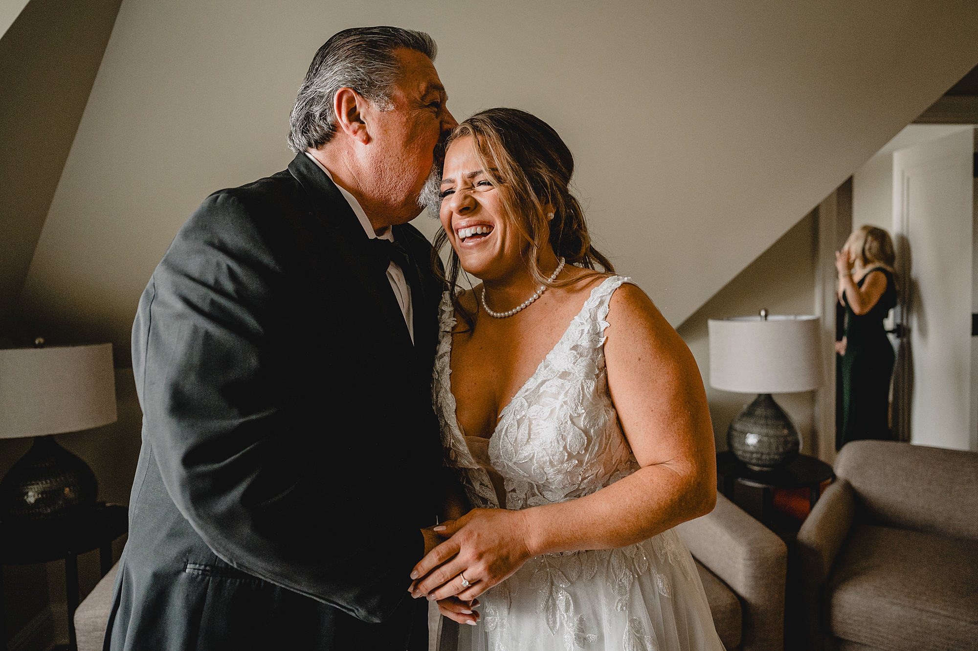 dad hugs bride kissing her head during first look