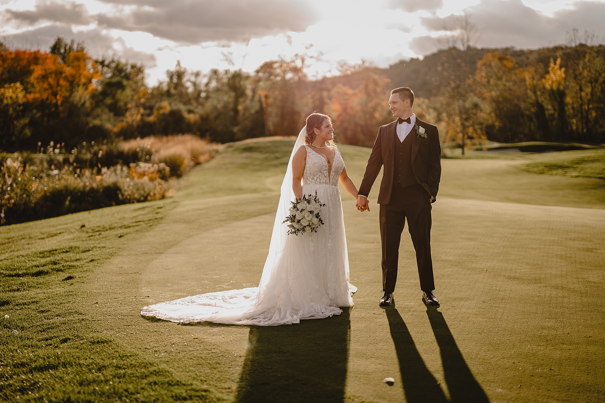 bride and groom stand on green at Hollow Brook Golf Club