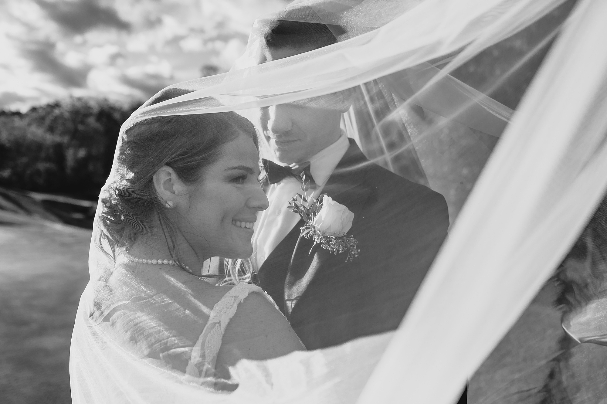 newlyweds hug under bride's veil at Hollow Brook Golf Club
