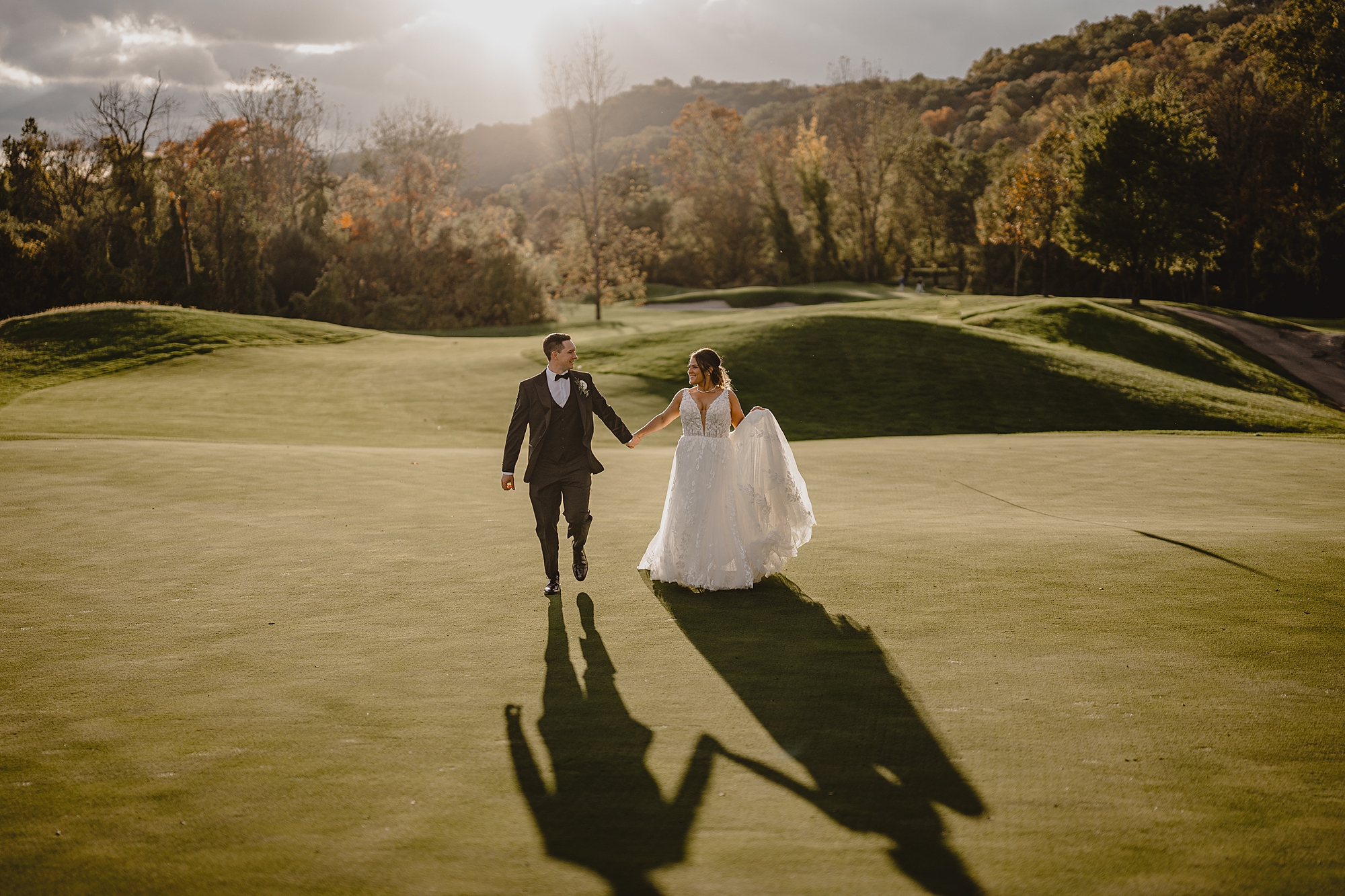 bride and groom run across golf course at Hollow Brook Golf Club