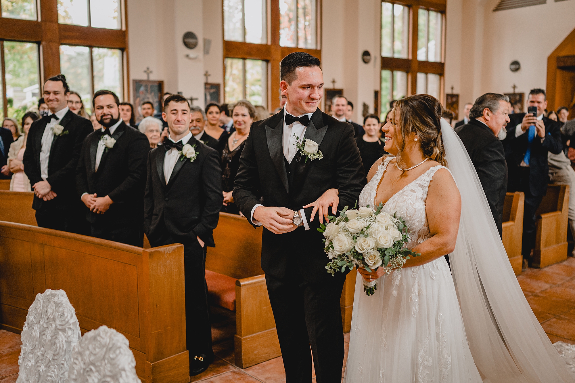 bride and groom smile at each other in church for traditional church ceremony in New York