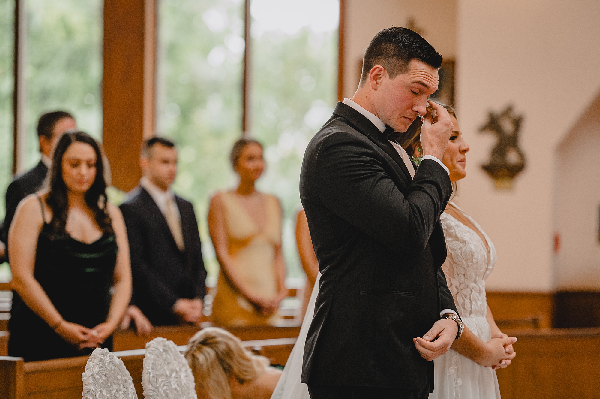 groom wipes away tear during traditional church ceremony in New York