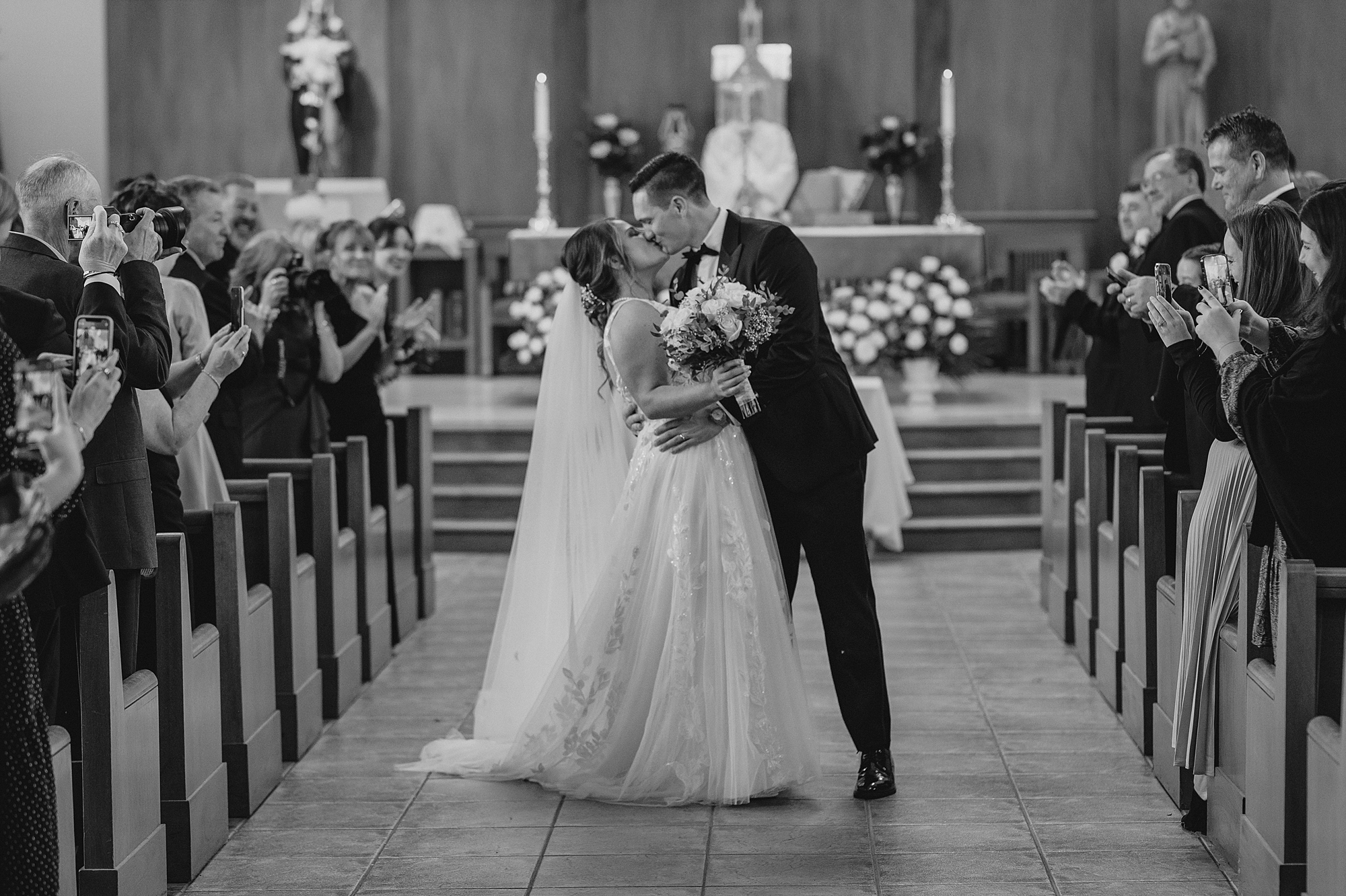 bride and groom kiss at altar after traditional church ceremony in New York