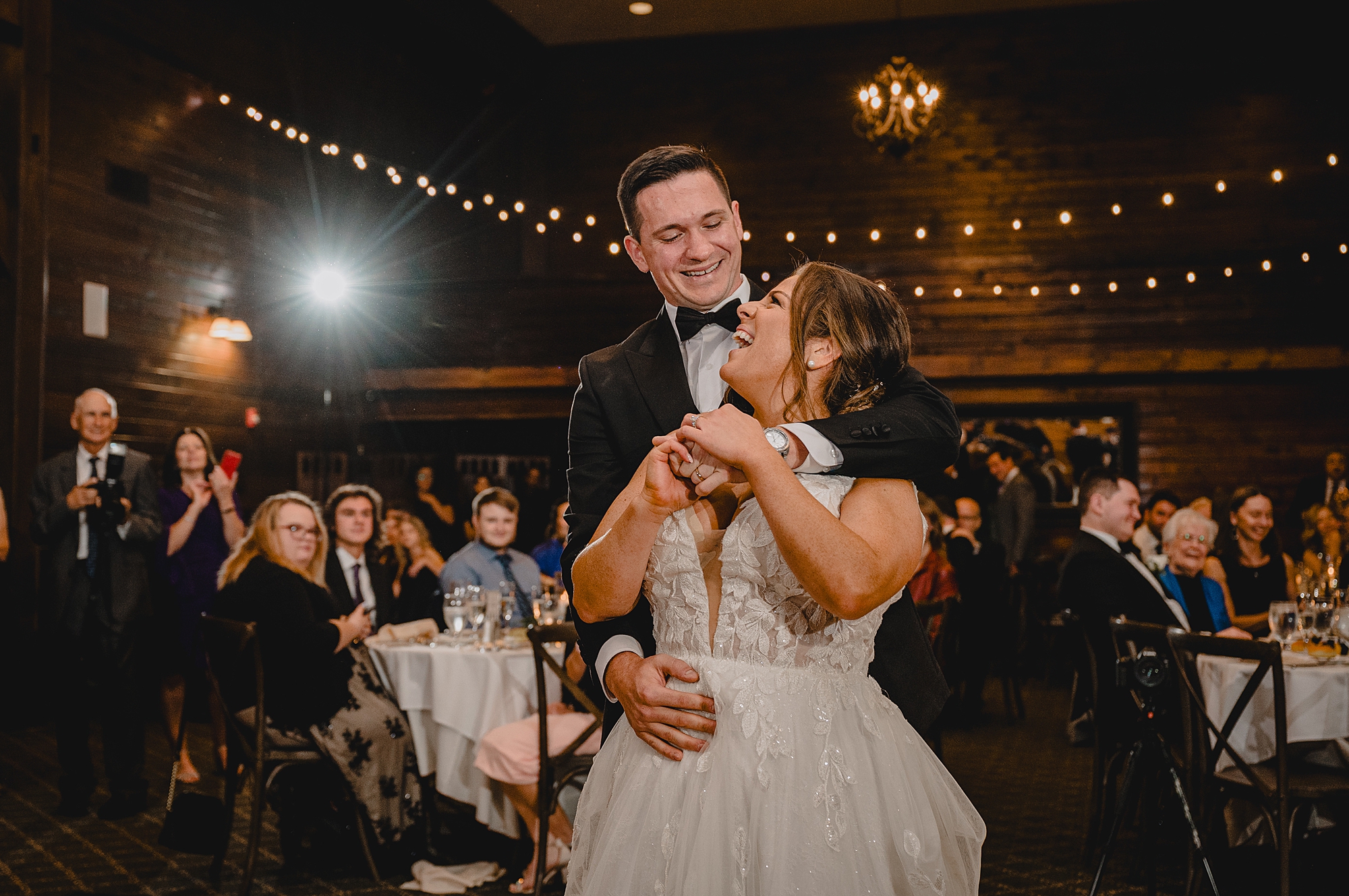 groom hugs bride from behind on dance floor
