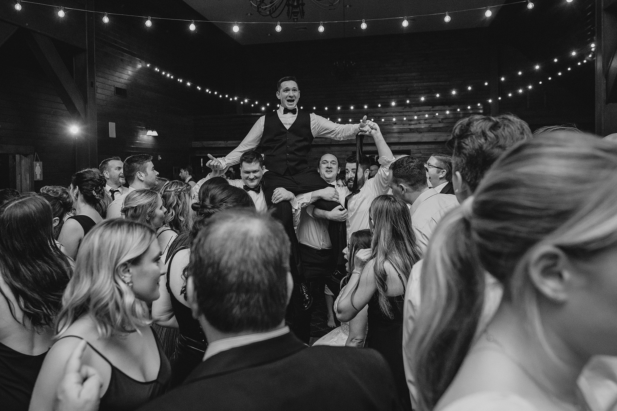 wedding guests dance lifting up groom during Cortlandt, NY reception