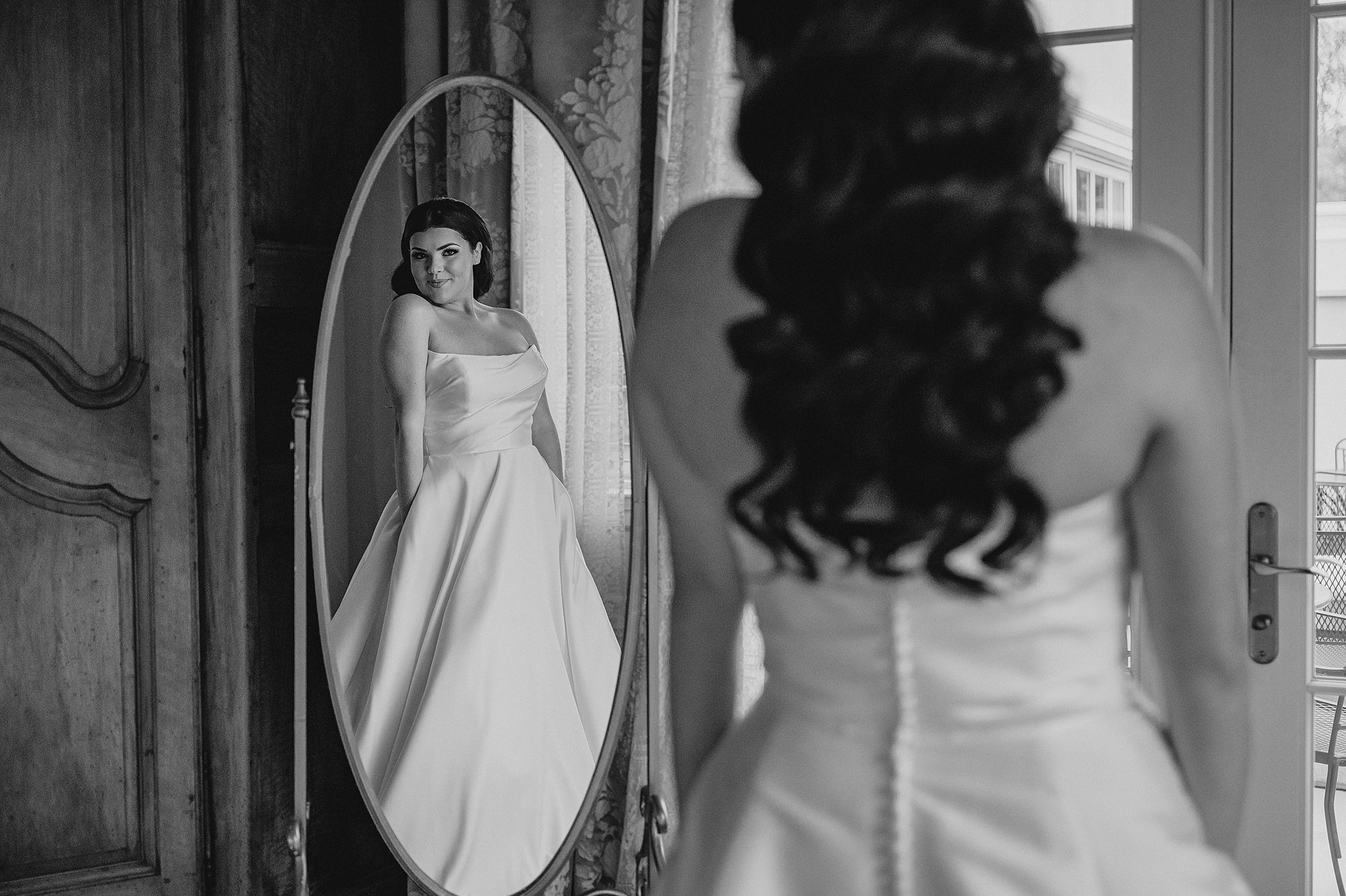 bride looks at reflection in mirror in bridal suite at Park Chateau