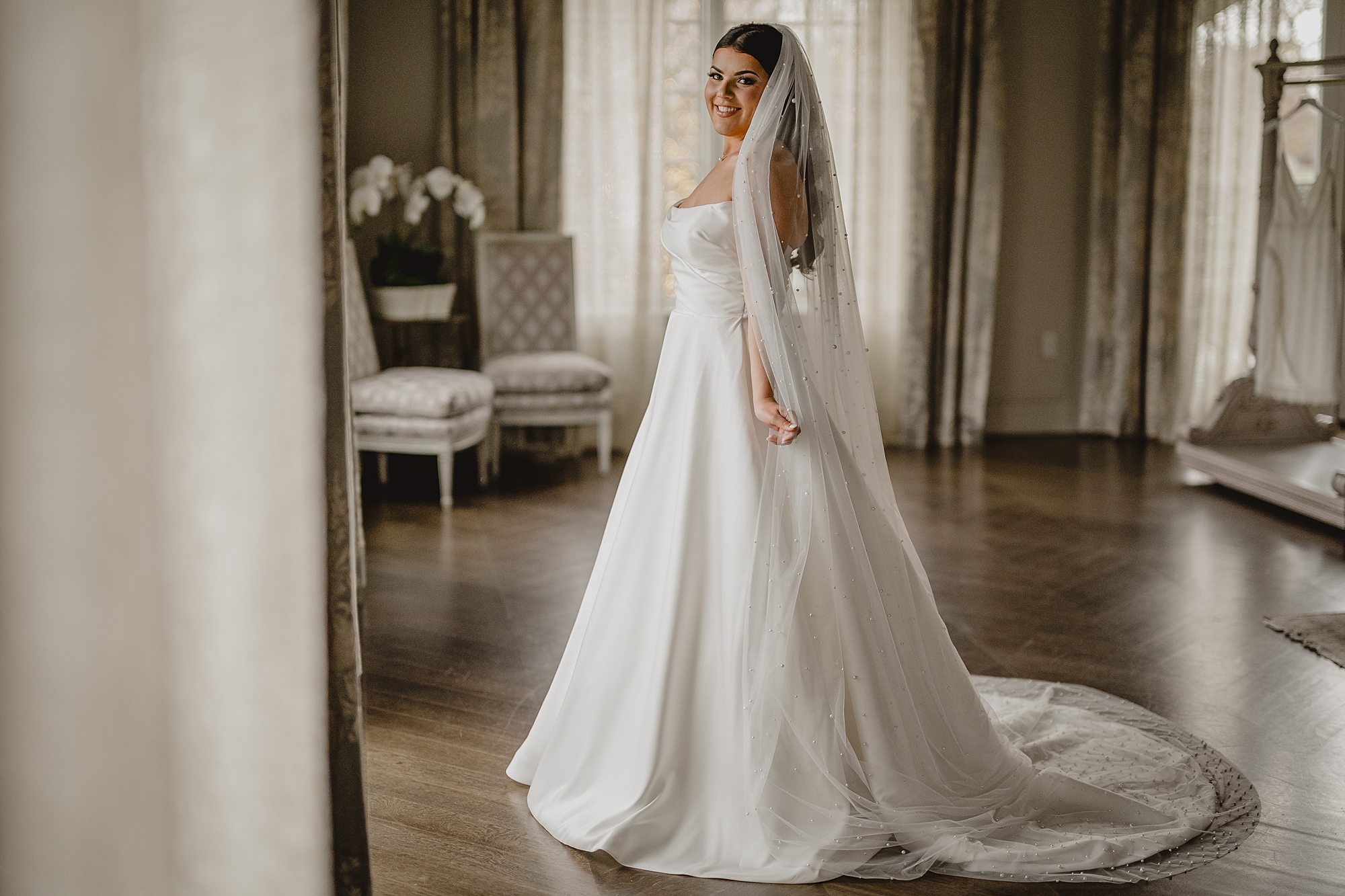 bride twirls in bridal suite of Park Chateau in strapless wedding gown
