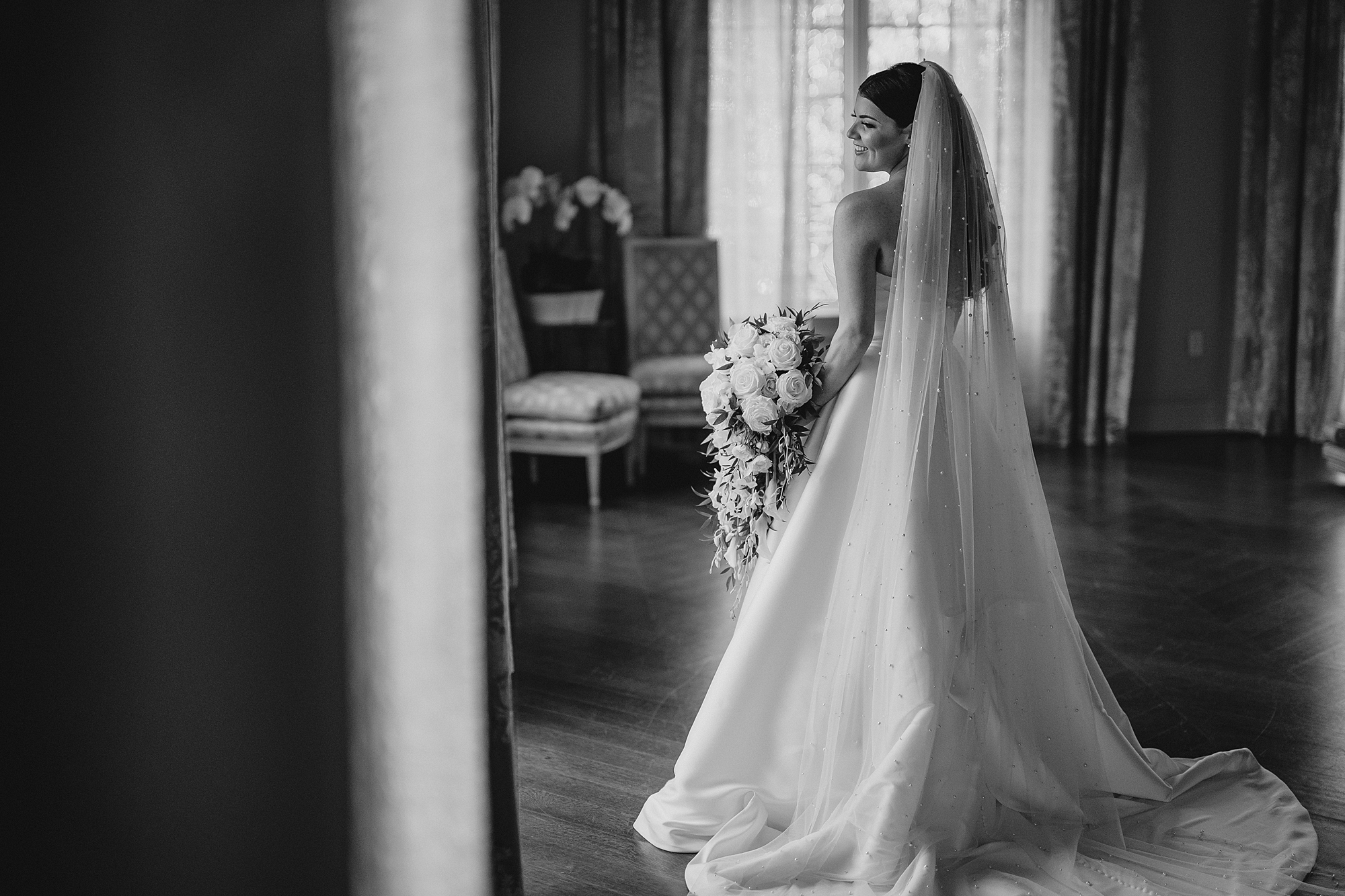 bride looks out window in bridal suite at Park Chateau