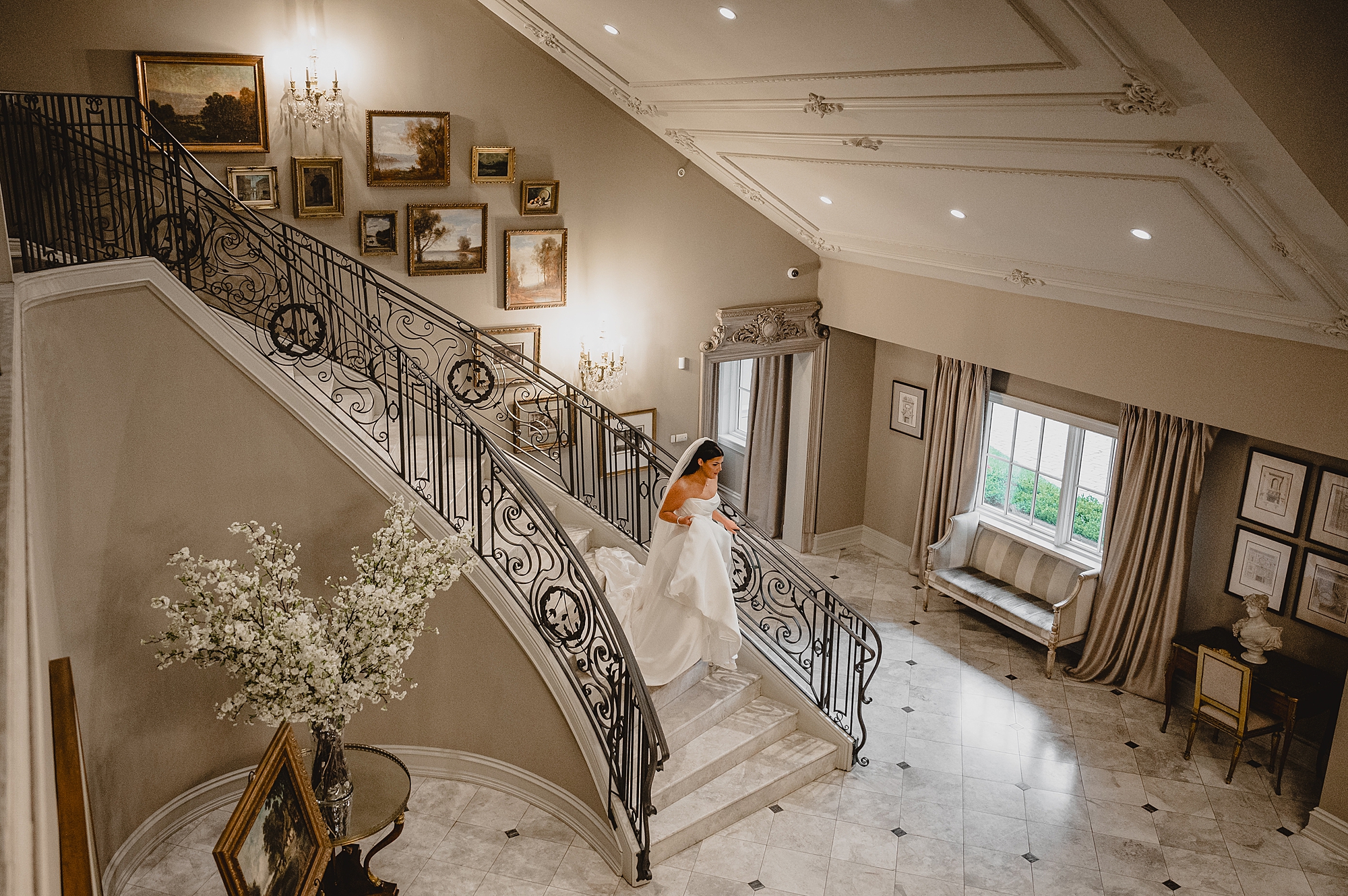 bride walks down grand staircase inside Park Chateau