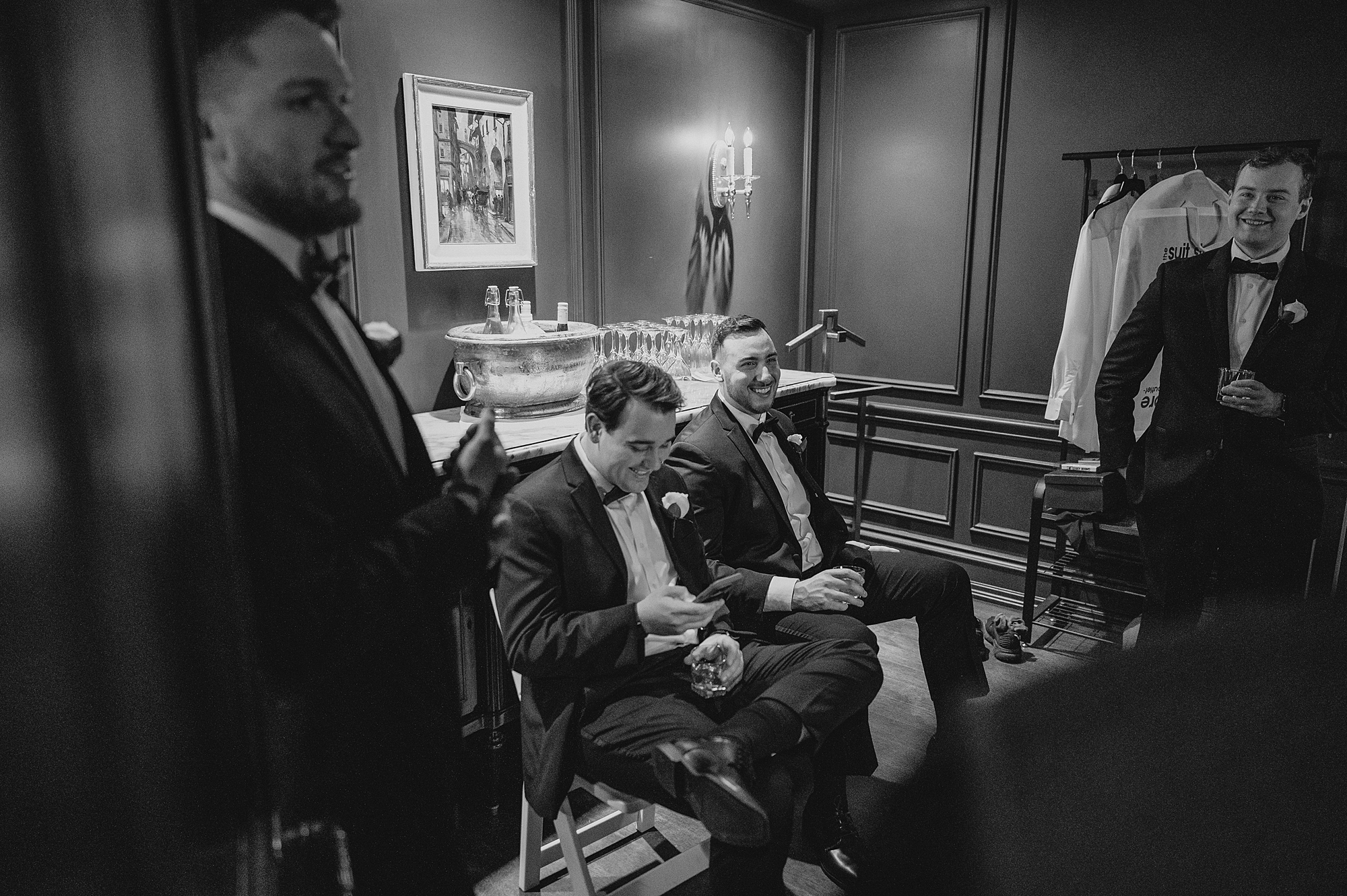 groomsmen sit laughing in suite at Park Chateau