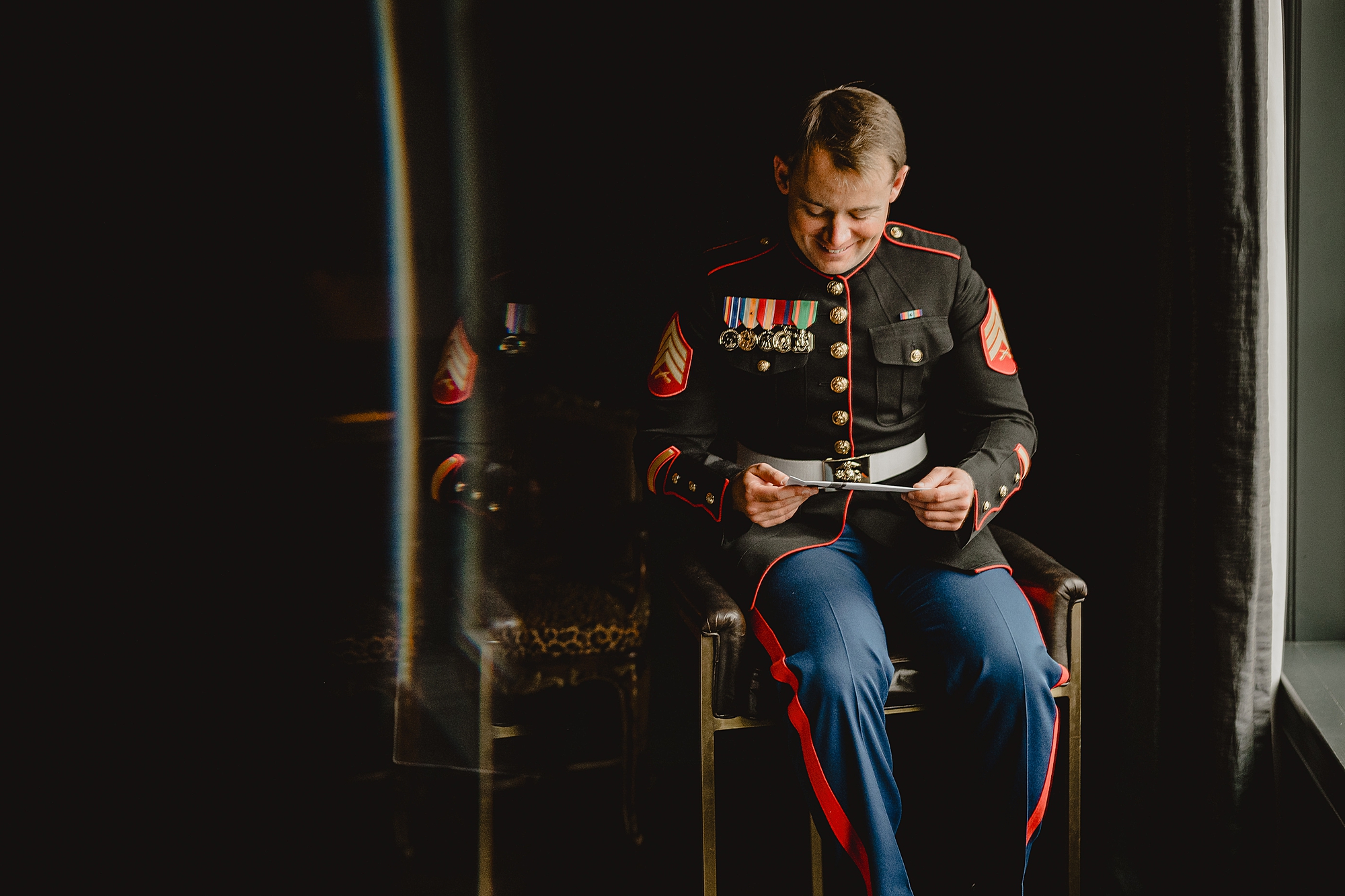 Marine in dress blues reads letter on wedding day at Park Chateau
