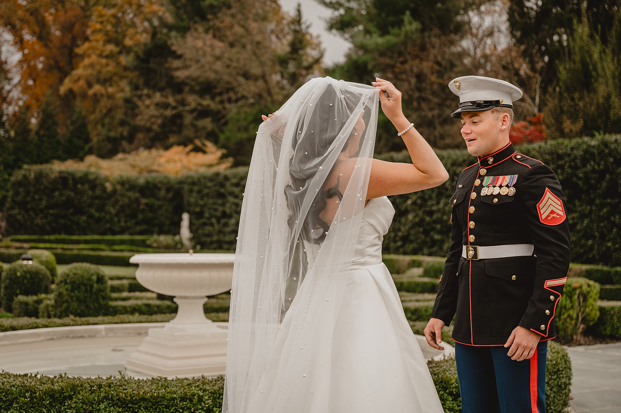 bride pulls veil around shoulders showing Marine