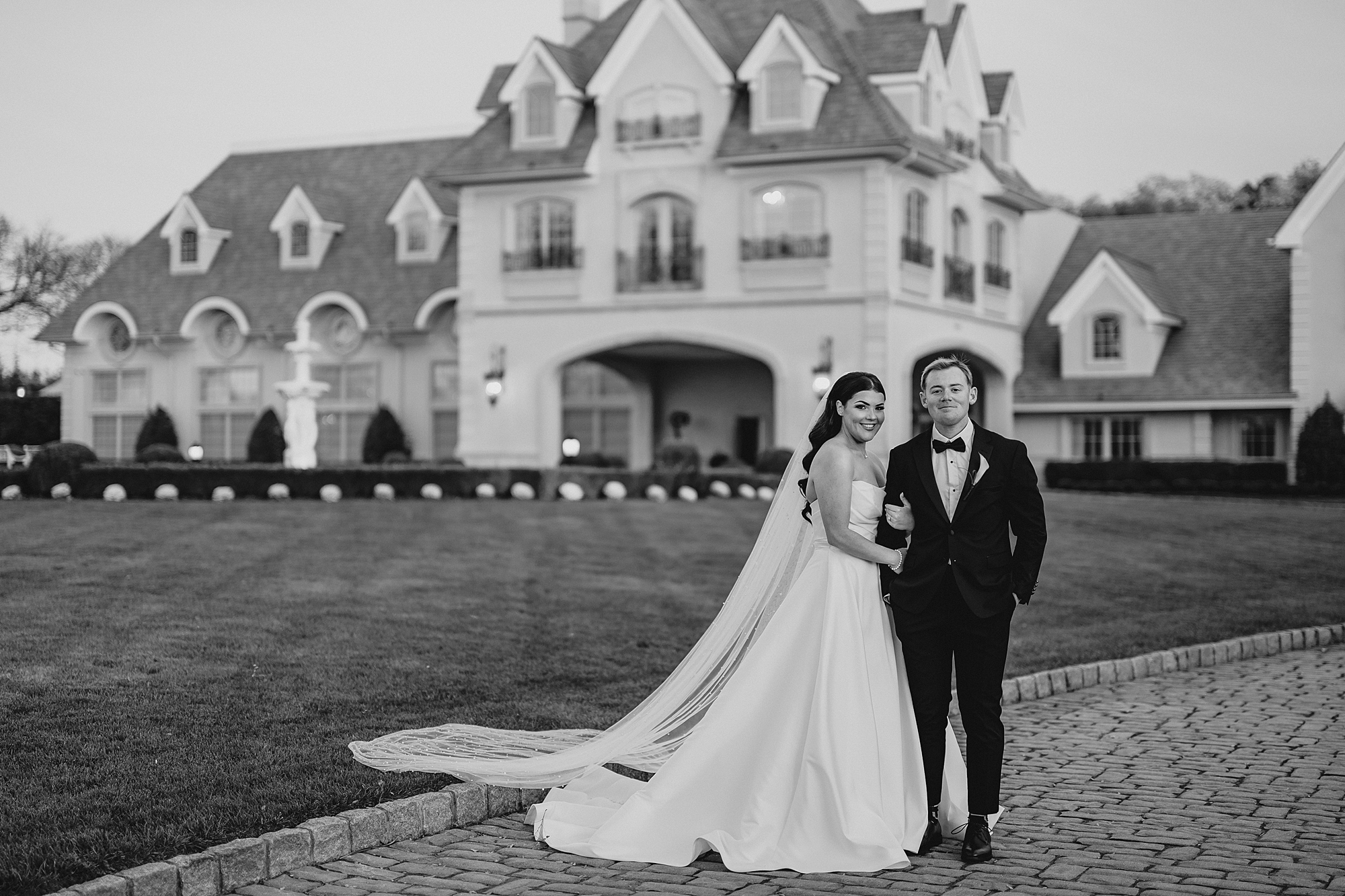 bride and groom pose in front of Park Chateau Estate 
