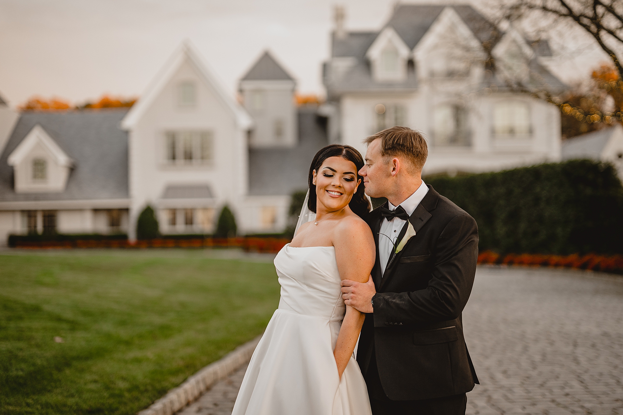 bride leans into groom hugging on driveway of Park Chateau
